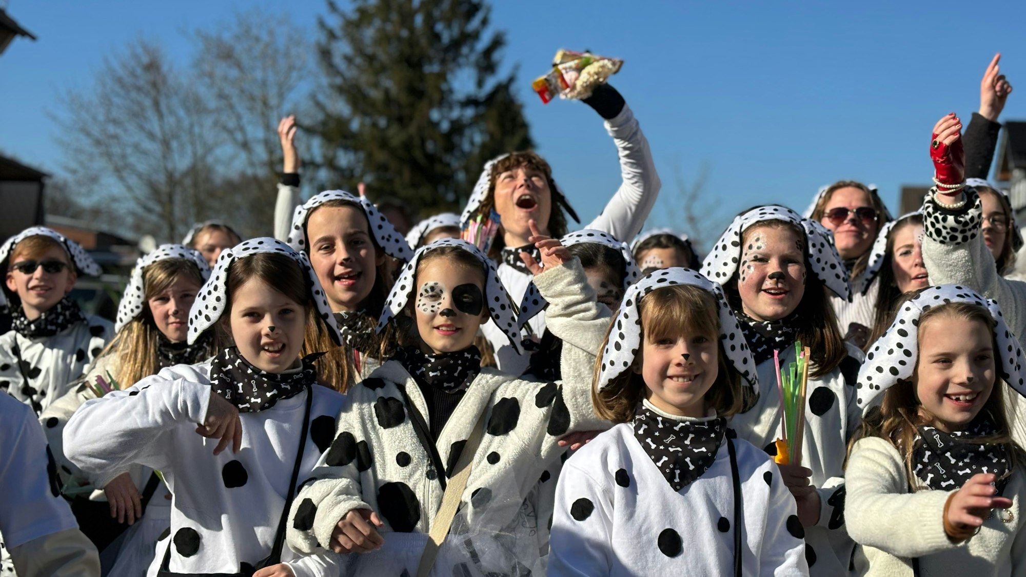 Zugteilnehmer sind als Dalmatiner verkleidet und blicken fröhlich in die Kamera.