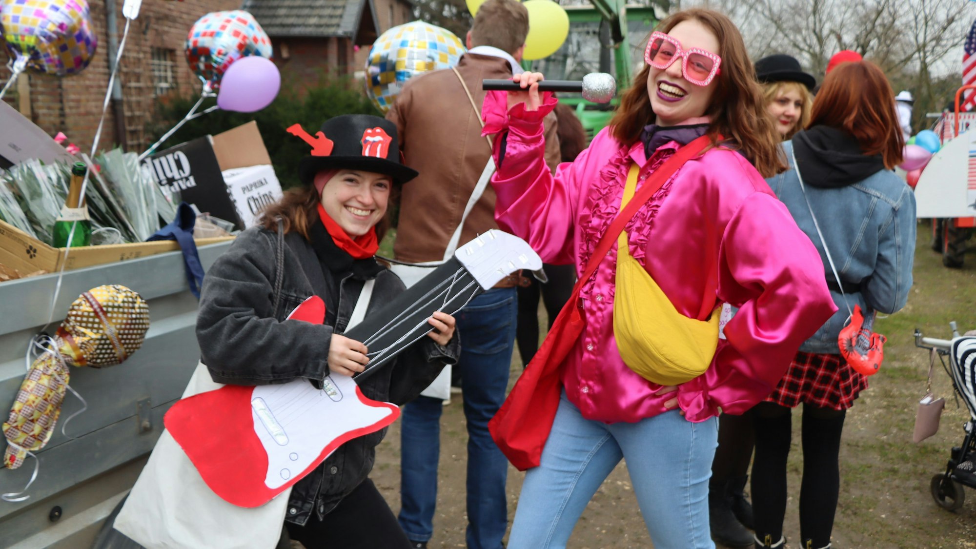 Auf dem Bild sind zwei junge Mädchen zu sehen, die sich als Rock-Musiker kostümiert haben.