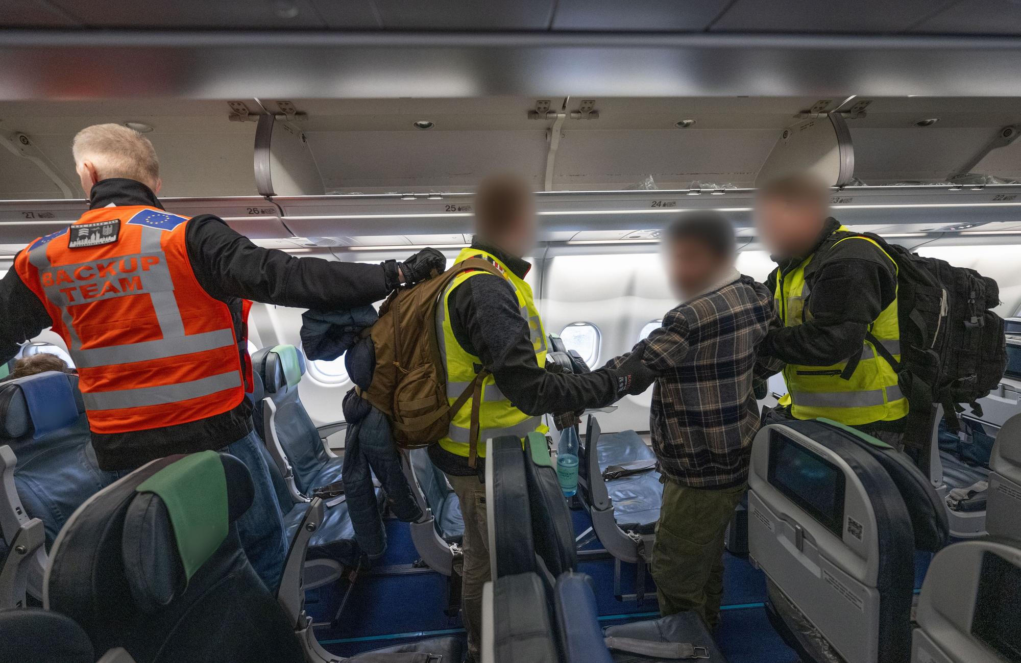 Beamte der Bundespolizei begleiten einen Mann in die Kabine eines Abschiebefluges nach Pakistan.