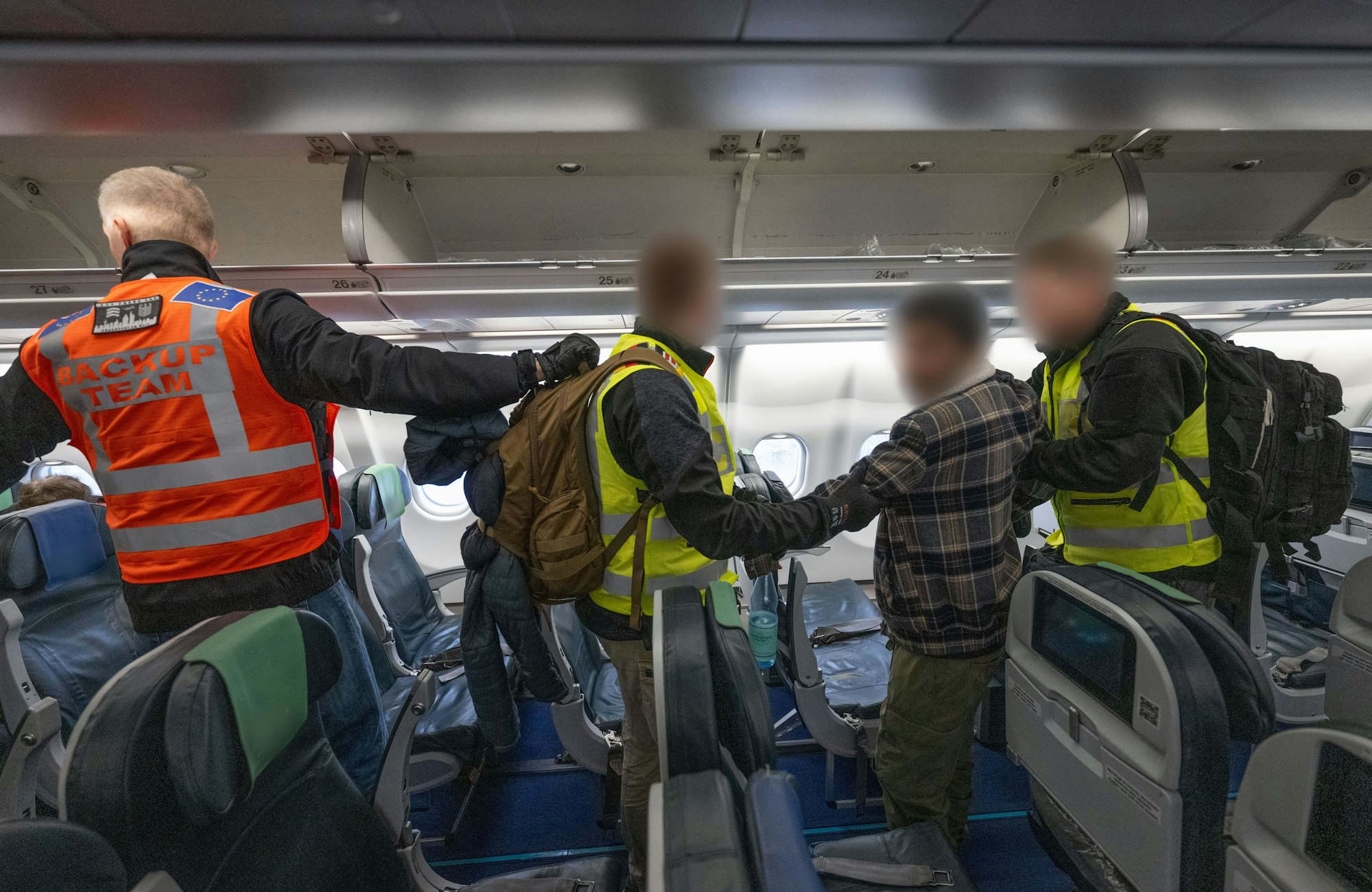 Beamte der Bundespolizei begleiten einen Mann in die Kabine eines Abschiebefluges nach Pakistan.