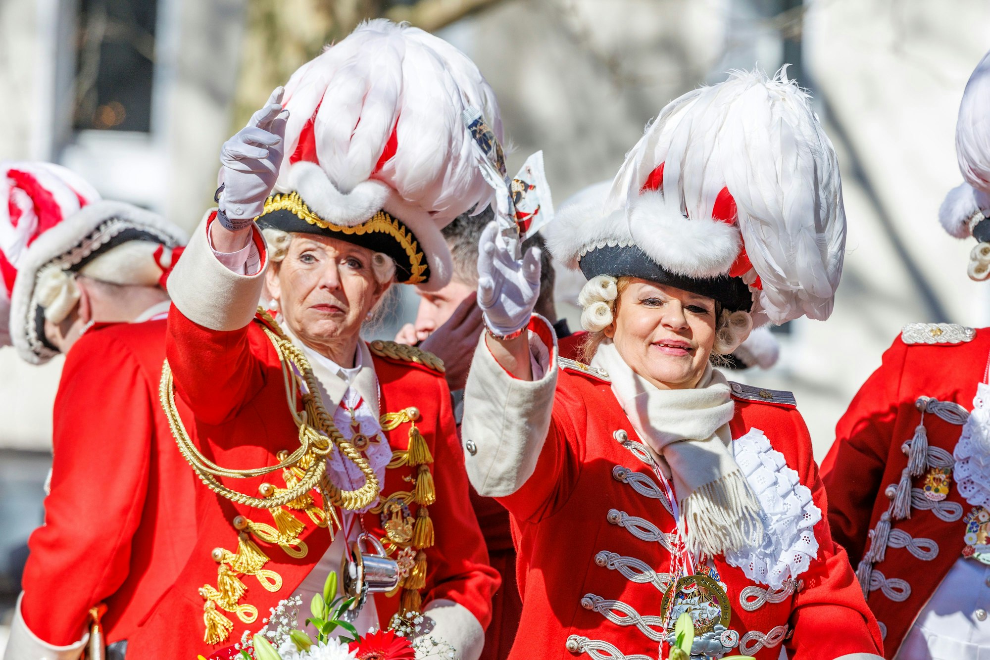 Kölns Oberbürgermeisterin Henriette Reker (l) und Nancy Faeser (SPD, r), Bundesinnenministerin, grüßen vom Wagen der „Roten Funken“.