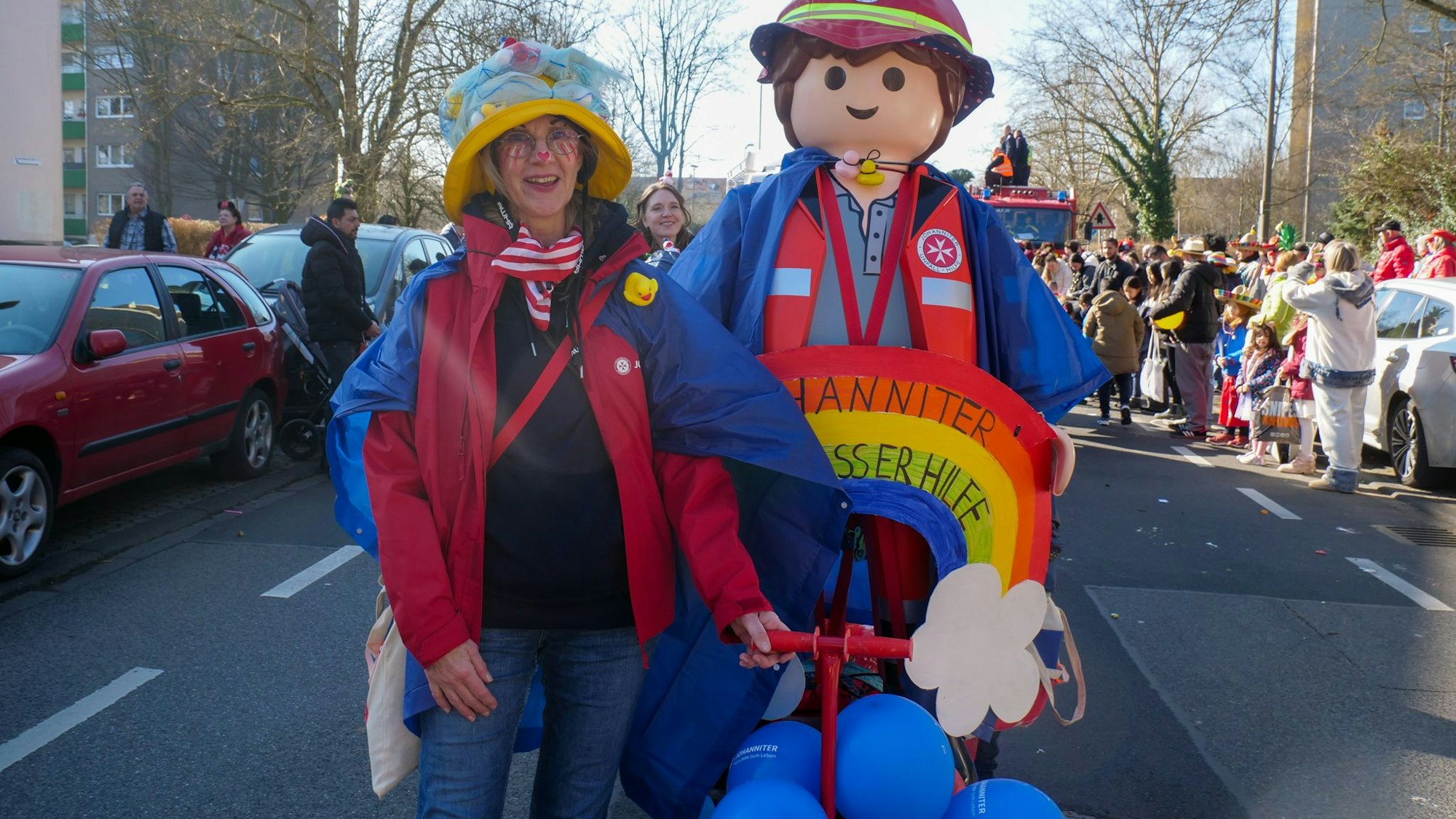 Auf dem Bild ist eine kostümierte Frau mit einem lebensgroßen Playmobil-Männchen zu sehen.