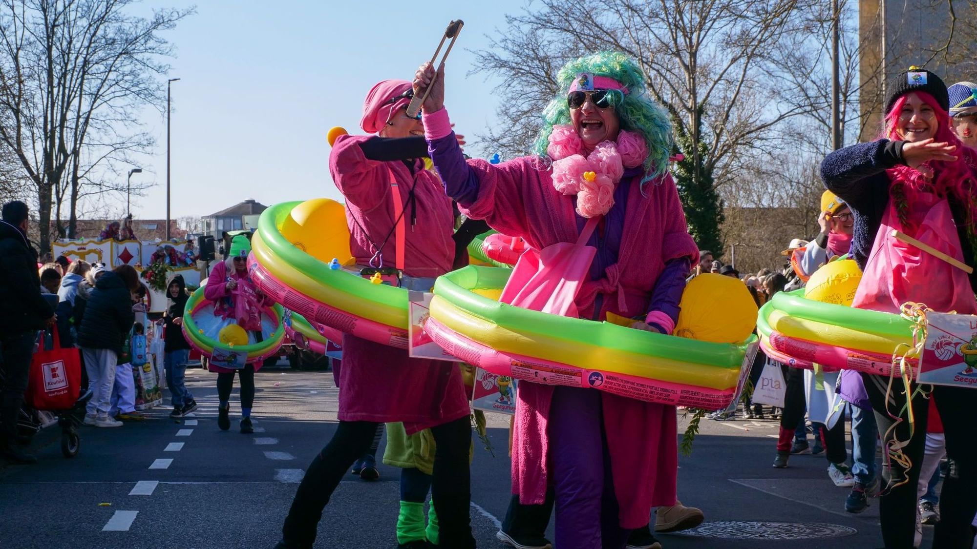 Auf dem Bild sind bunt kostümierte Männer mit Minipools zu sehen.