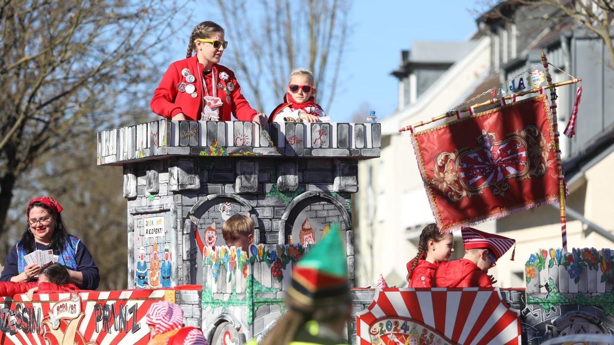 Eine Kinderprinzessin auf einem bunten Karnevalswagen.