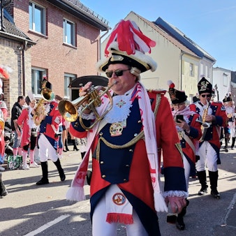 Die Mitglieder des Funkencorps tragen Gardeuniform und spielen ihre Blasinstrumente.