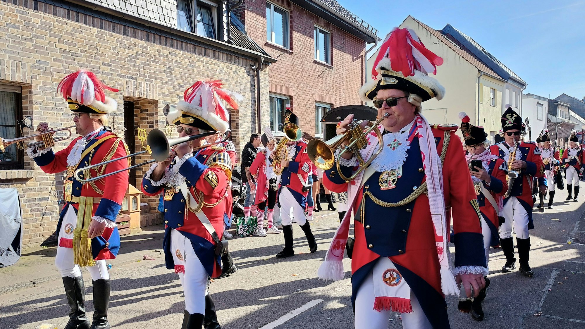 Die Mitglieder des Funkencorps tragen Gardeuniform und spielen ihre Blasinstrumente.