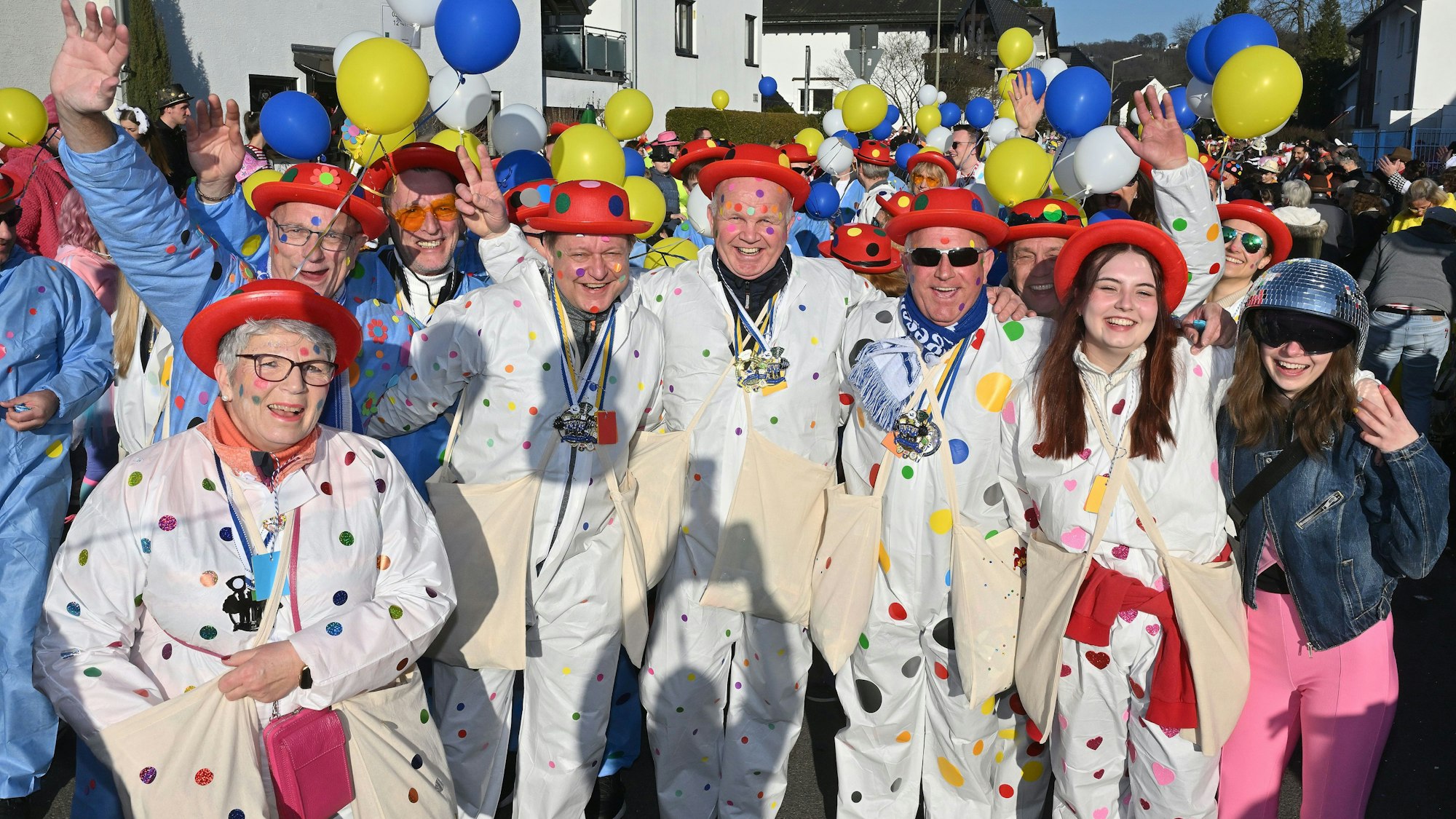 Eine bunt gekleidete Gruppe geht im Karnevalszug mit.