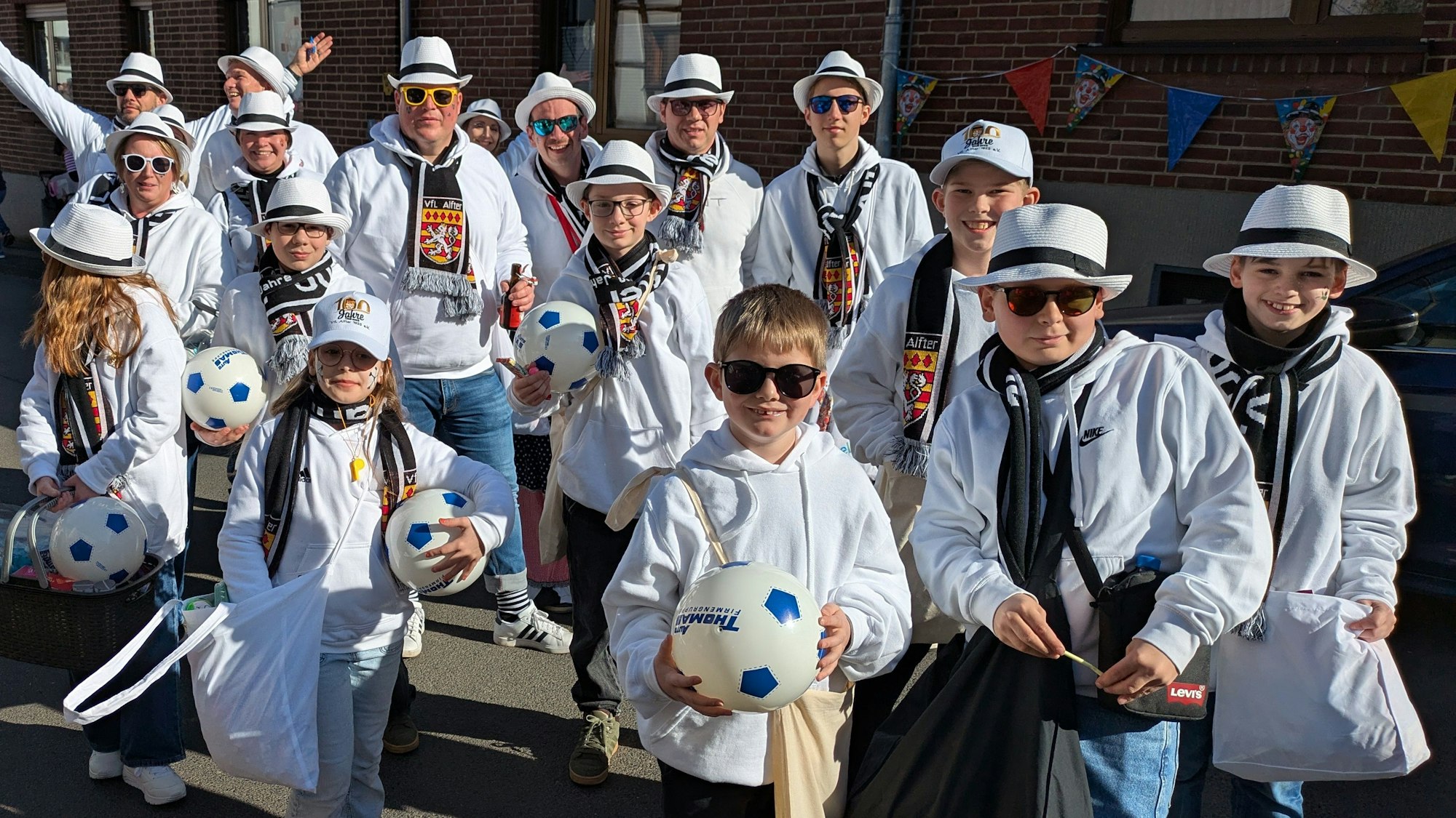 Die Jugendgruppe des VfL Alfter in weißen Hoodies, dunklen Brillen und mit Hüten.