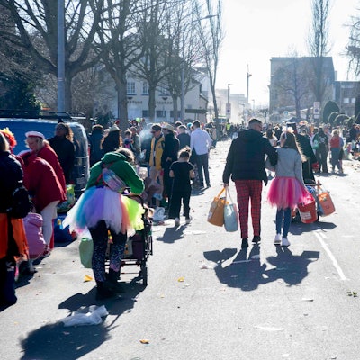 Das Bild zeigt zahlreiche Jecke, die mit Tüte voller Kamelle den Heimweg antreten.