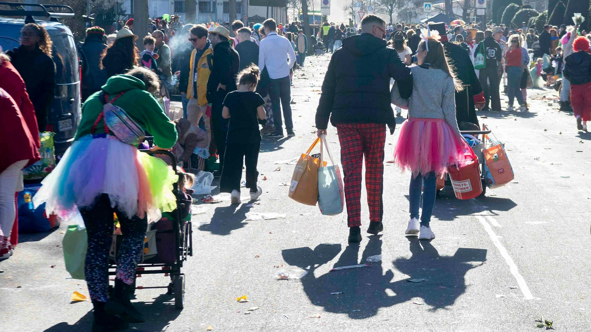 Das Bild zeigt zahlreiche Jecke, die mit Tüte voller Kamelle den Heimweg antreten.