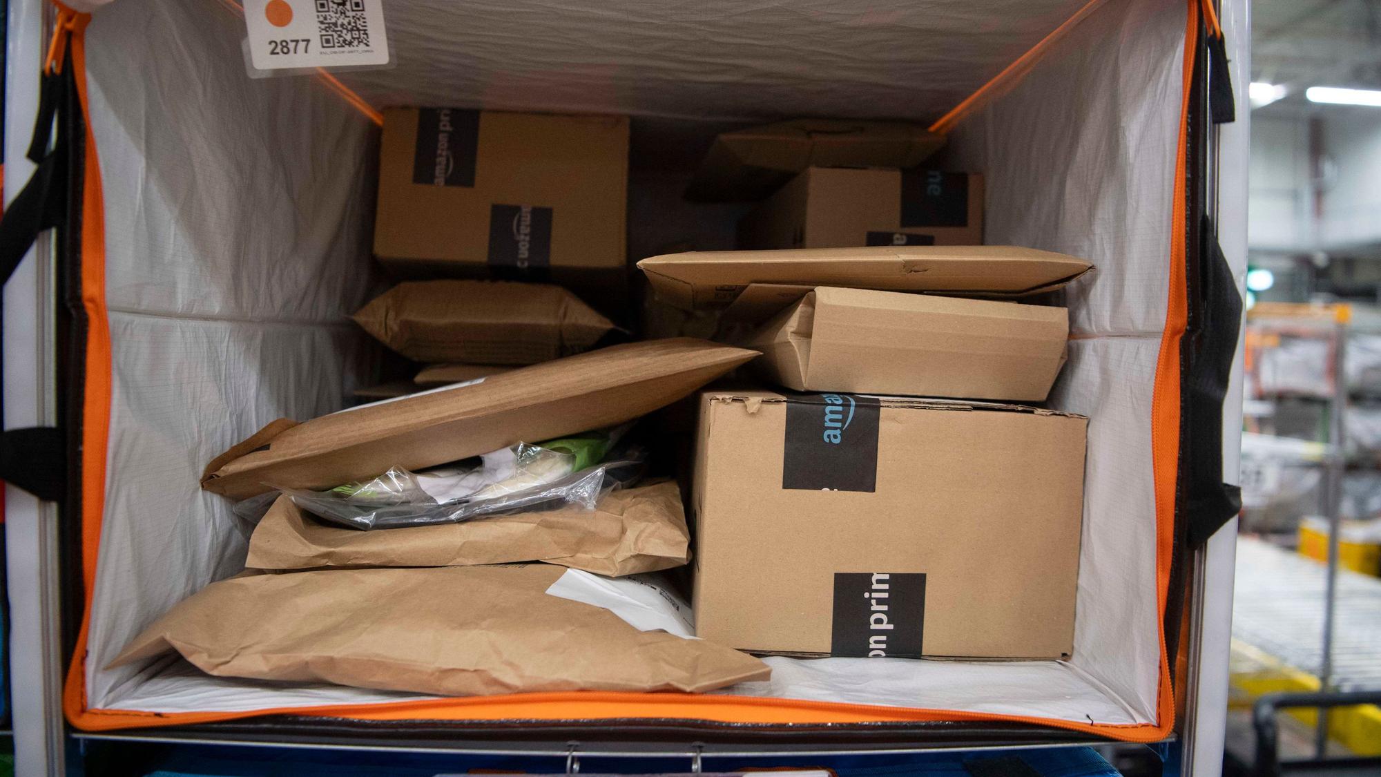Das Bild zeigt eine große Versandtasche, in der zahlreiche Sendungen vom Internetanbieter Amazon liegen.