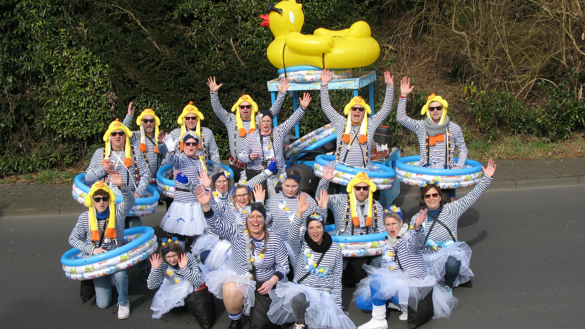 Eine Gruppe mit Ringel-Hemden, Kinderplanschbecken und Entenmützen auf dem Kopf.