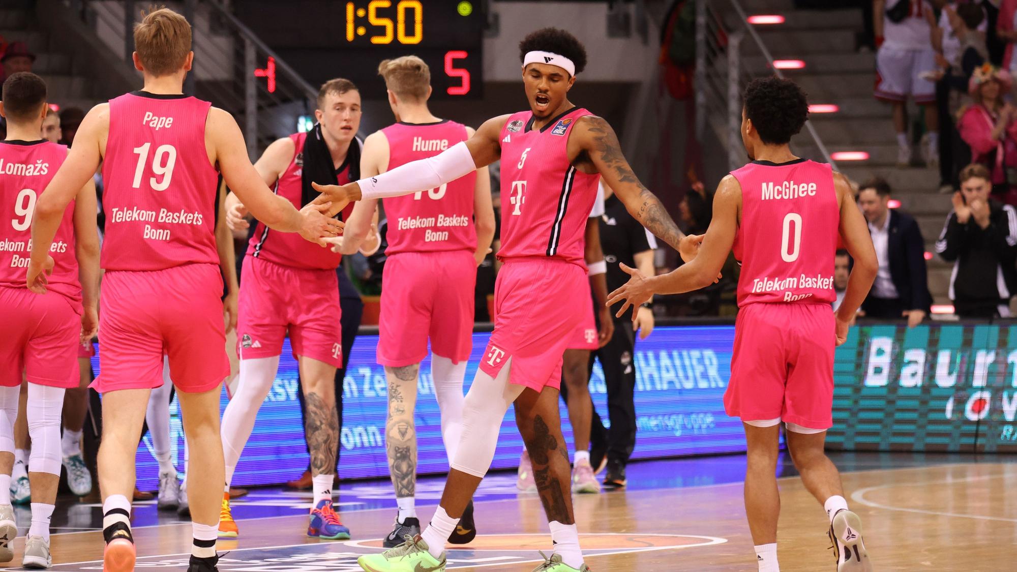 Der Bonner Rivaldo Soares (Mitte) feuert seine Mitspieler Till Pape (l.) und Darius McGhee an.
