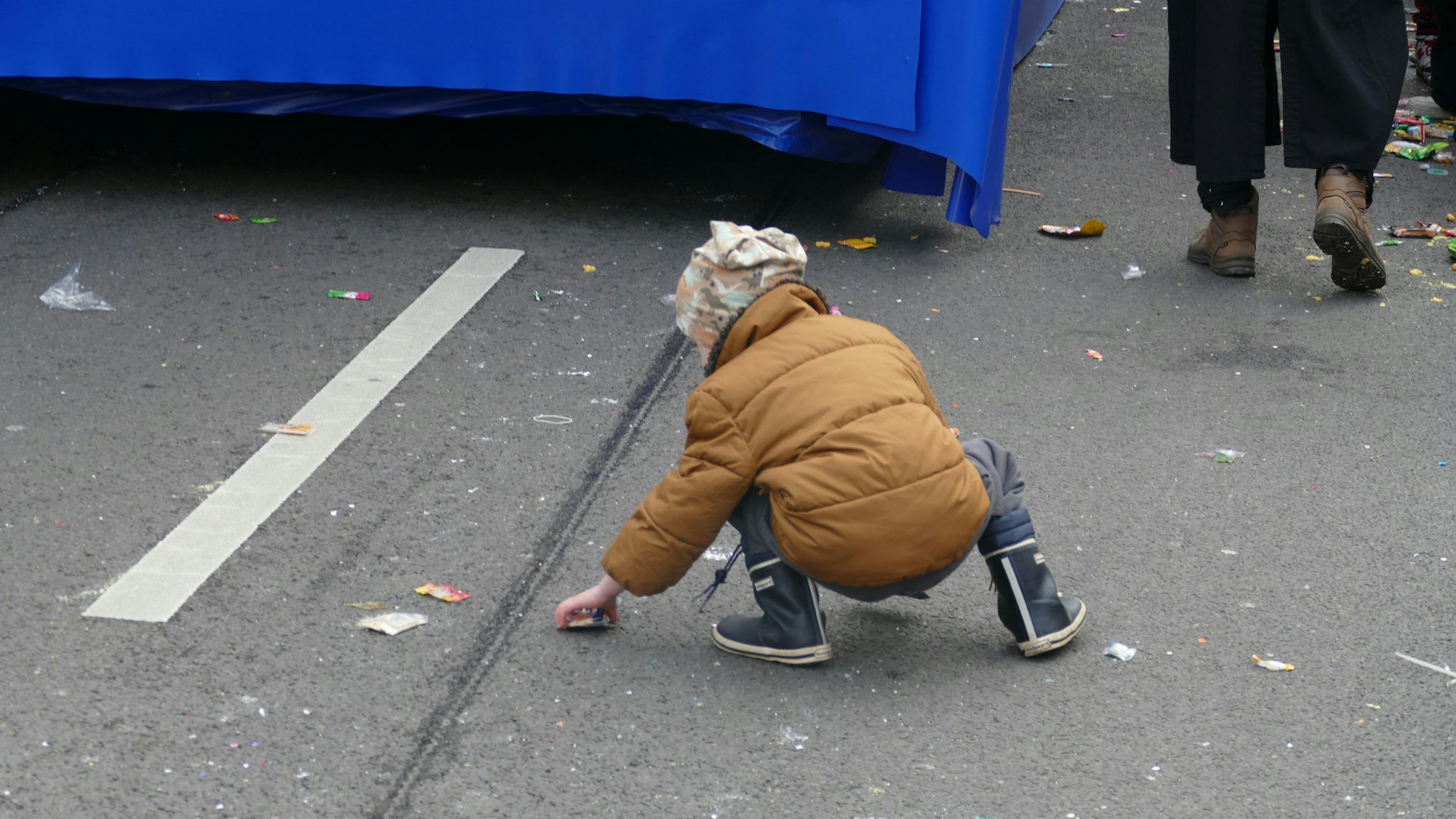 Ein Kind greift nach einer Waffel, die direkt neben der Urinspur liegt.
