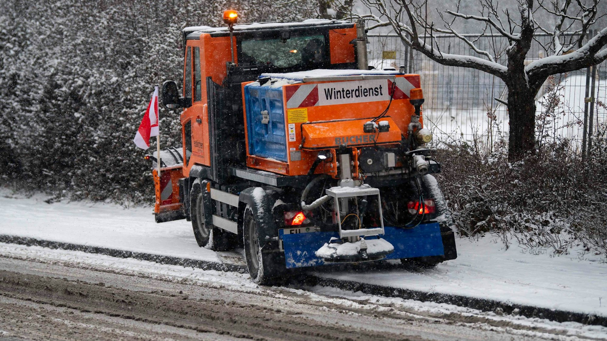 Das Bild zeigt ein Fahrzeug des Winterdienstes, wie es versucht, auf einen Bürgersteig zu fahren.