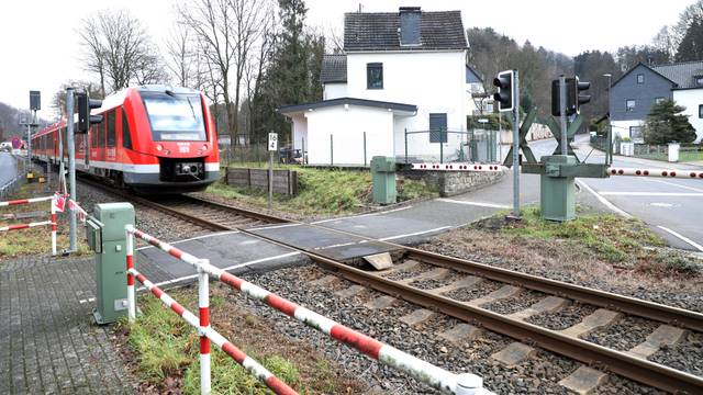 Eine Regionalbahn 25 fährt auf den Bahnübergang Hofferhofer Straße in Rösrath-Hoffnungsthal zu.