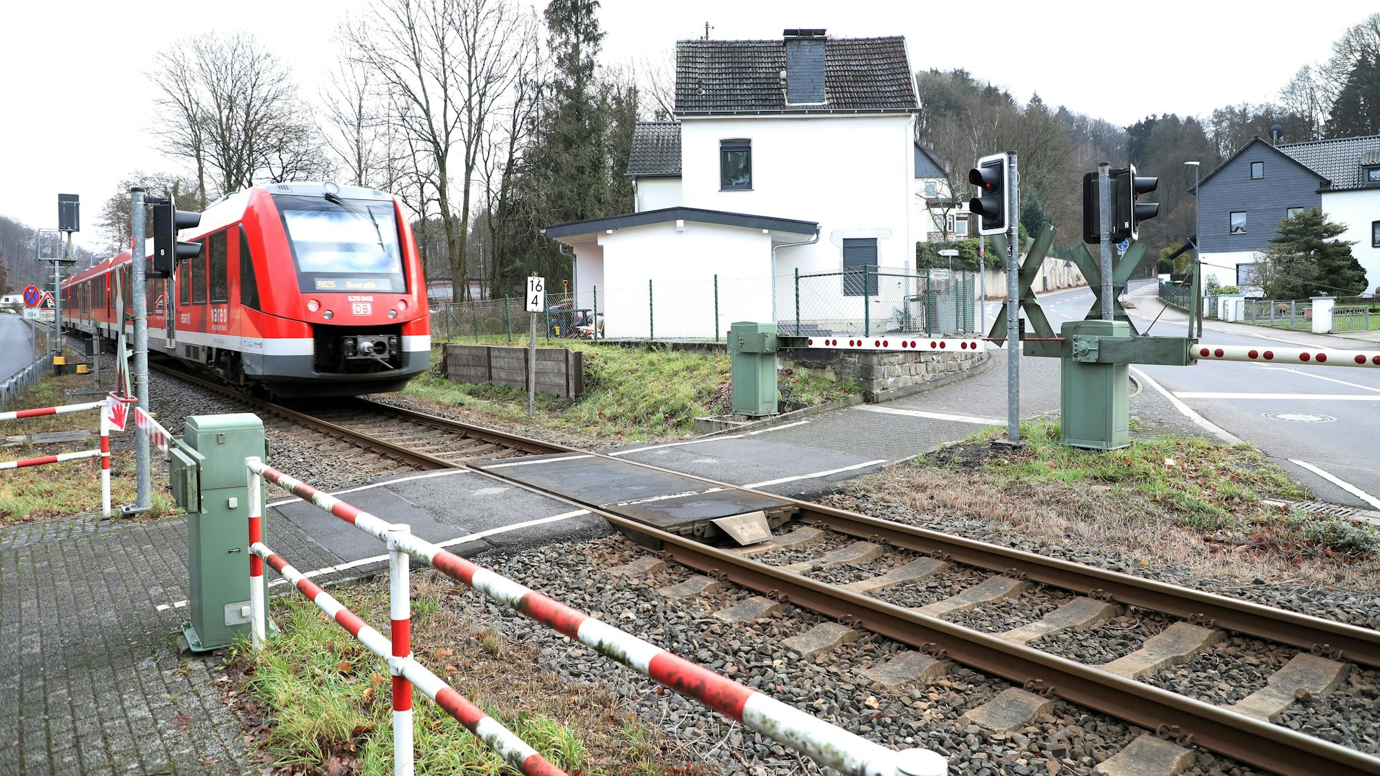 Eine Regionalbahn 25 fährt auf den Bahnübergang Hofferhofer Straße in Rösrath-Hoffnungsthal zu.