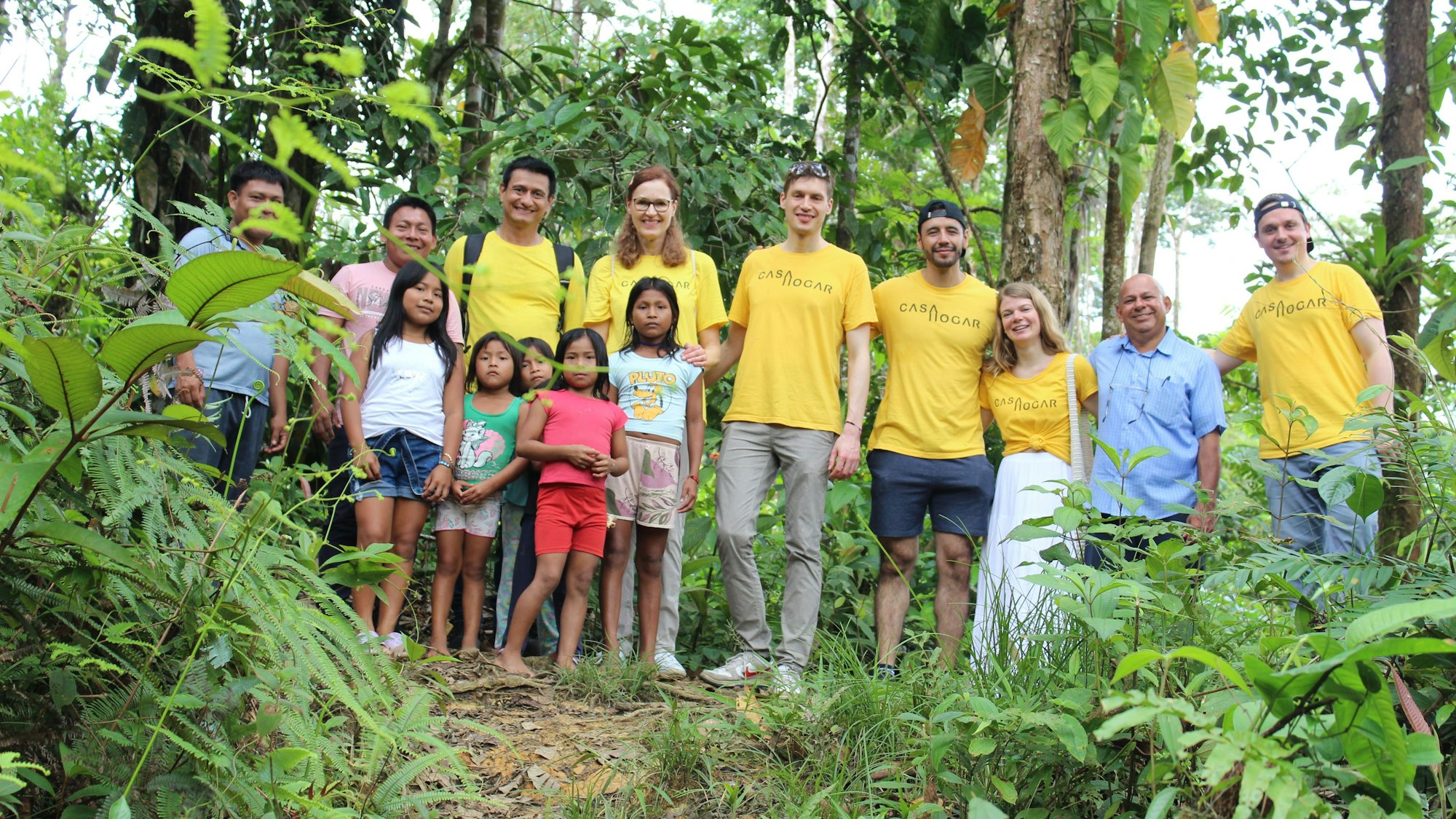 Die Besucher aus Deutschland stehen mit einigen kolumbianischen Mädchen im Dschungel.
