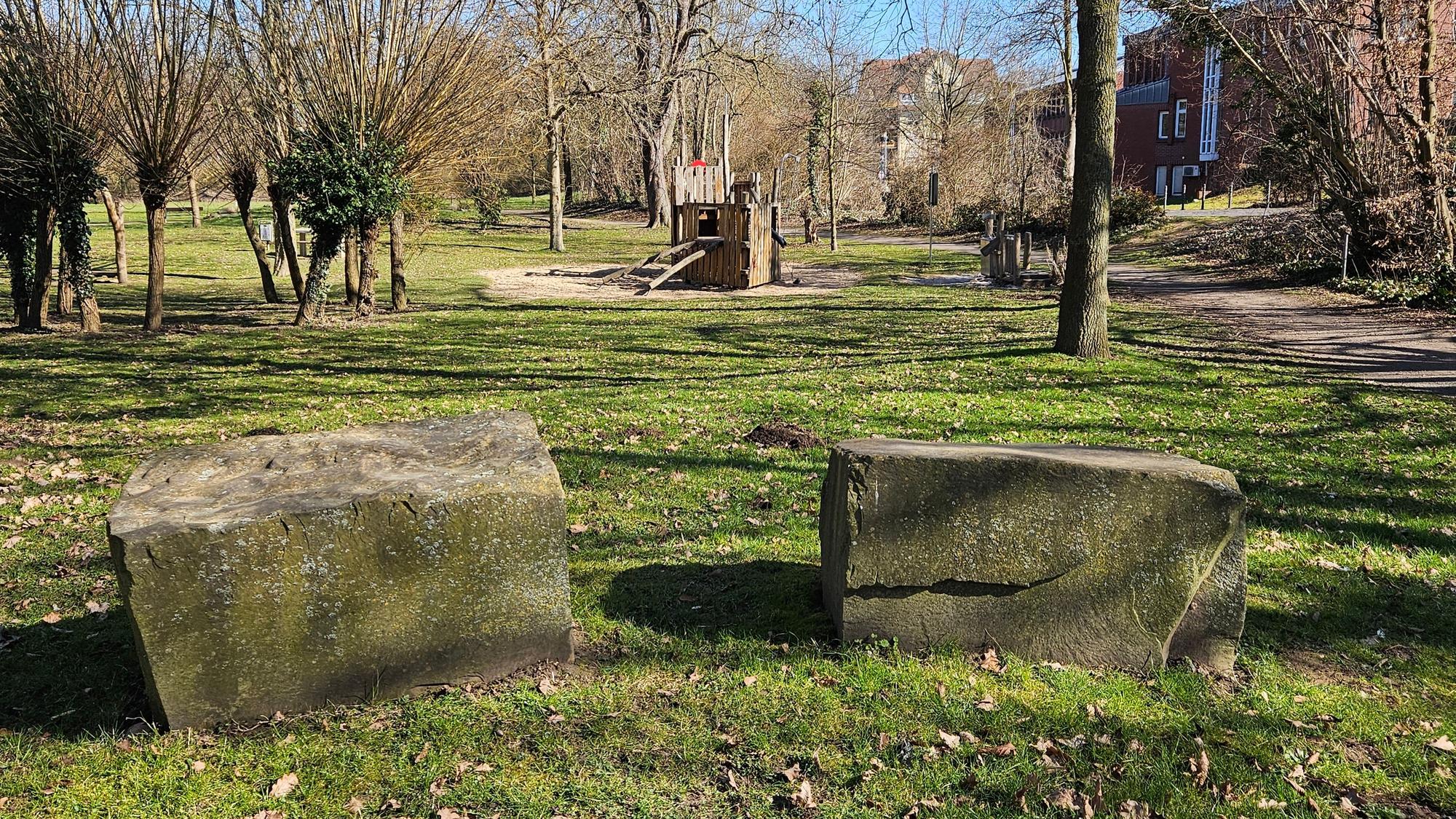 Zu sehen ist ein Park mit Findlingen und einem Spielplatz.