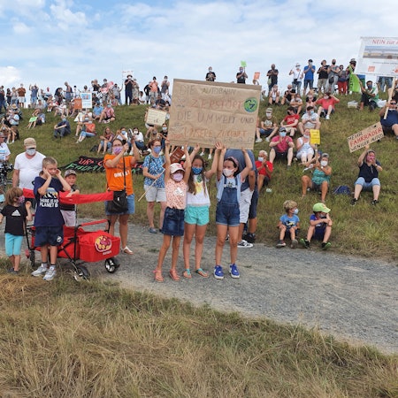 Auf dem Rheindamm zischen Köln-Porz-Langel und Niederkassel-Lülsdorf demonstrieren im September zahlreiche Menschen mit Transparenten gegen die geplante Rheinspange.