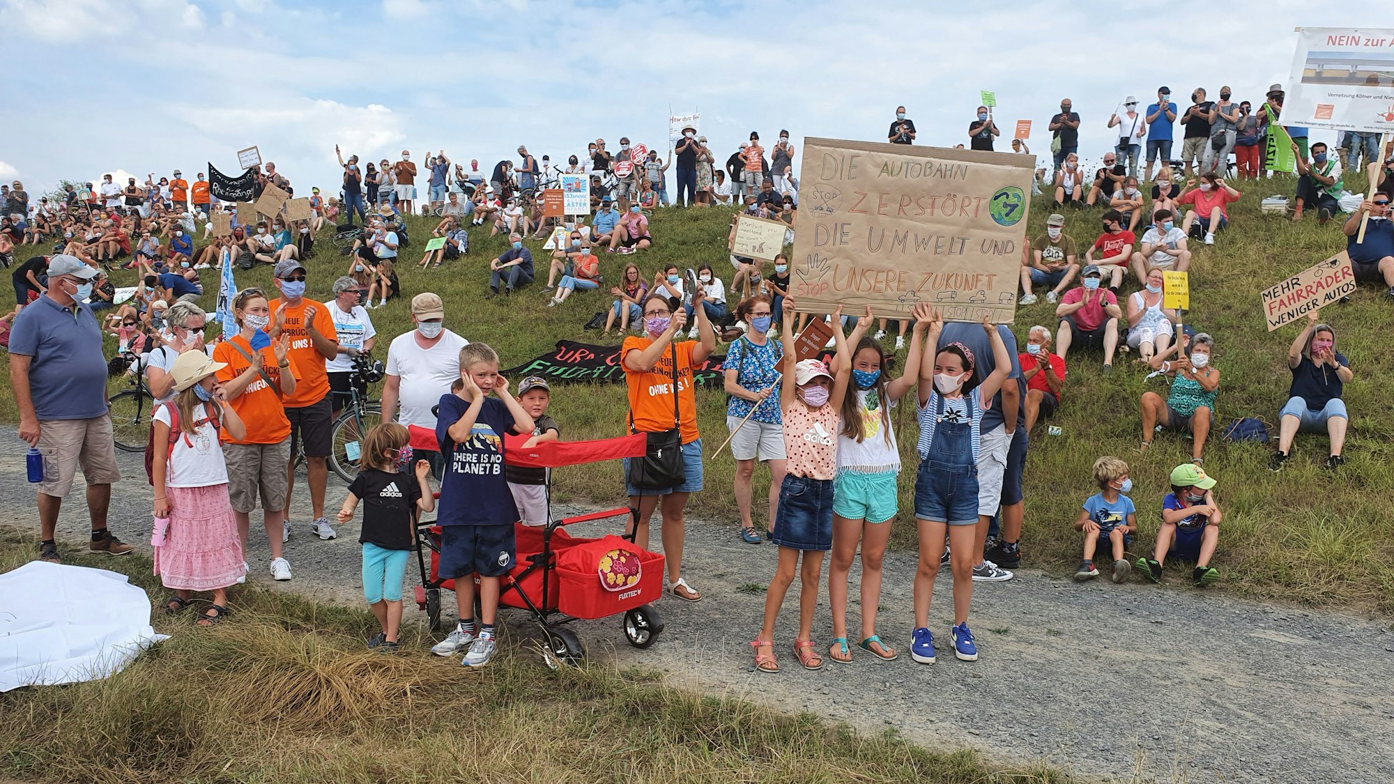 Auf dem Rheindamm zischen Köln-Porz-Langel und Niederkassel-Lülsdorf demonstrieren im September zahlreiche Menschen mit Transparenten gegen die geplante Rheinspange.