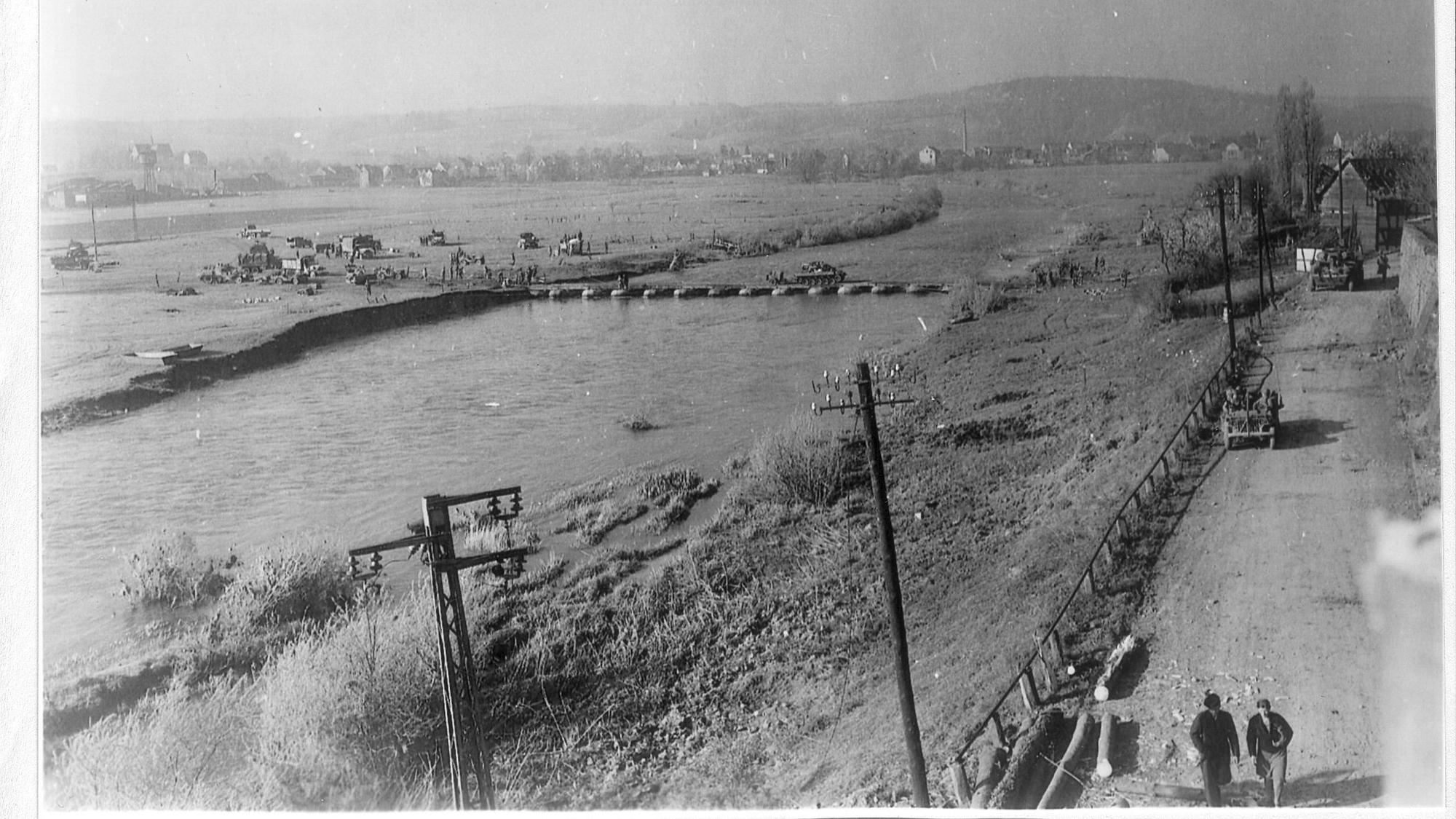 Ein Panzer fährt auf einer Pontonbrücke über einen Fluss.