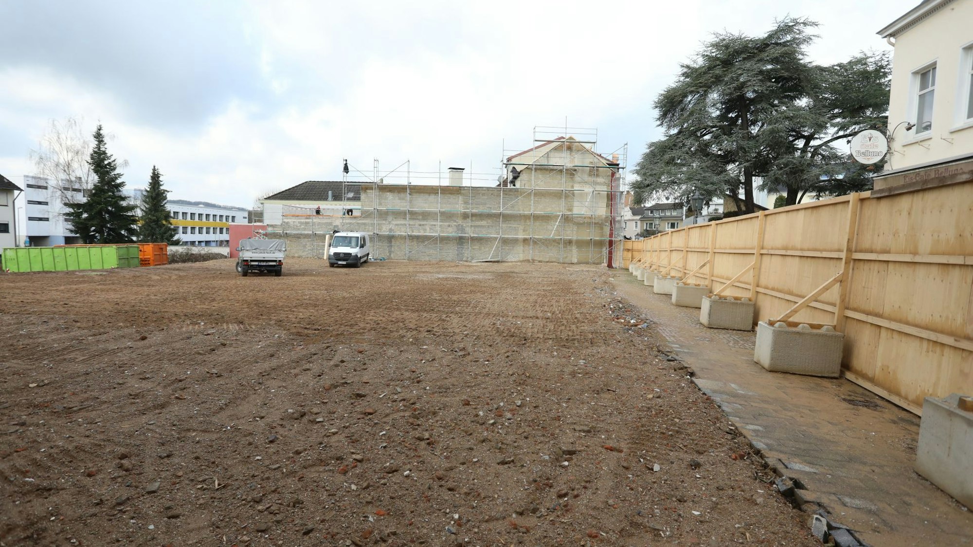 Eine große, mit Sand bedeckte Fläche, links im Hintergrund das ehemalige Gebäude der Post in Bad Honnef.
