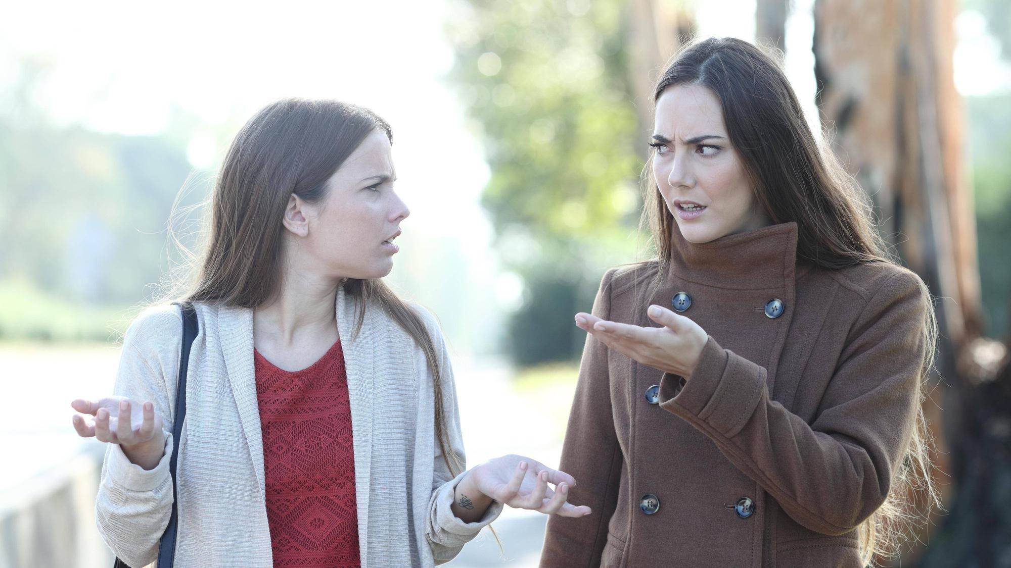 Zwei Frauen diskutieren, während sie durch einen Park spazieren