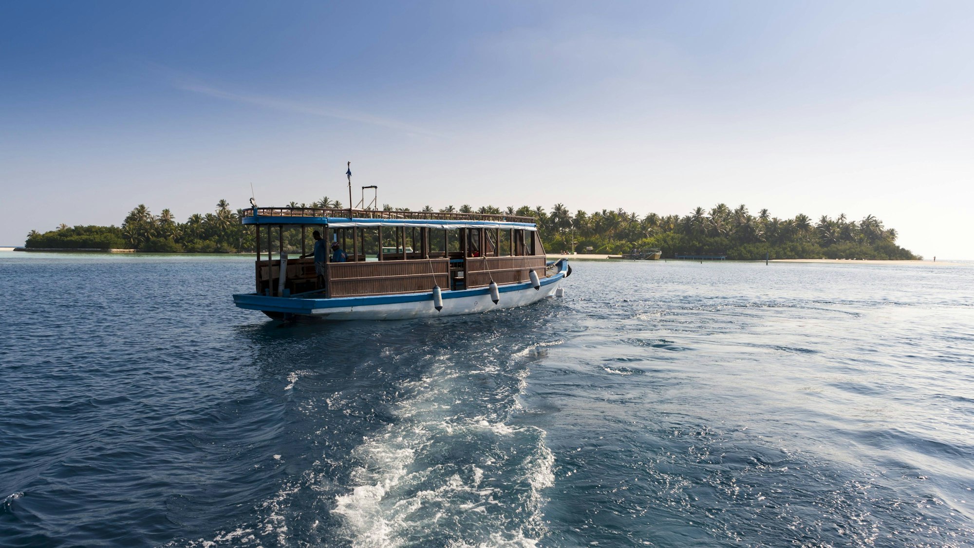 Eine Passagierfähre vor einem Atoll der Malediven.