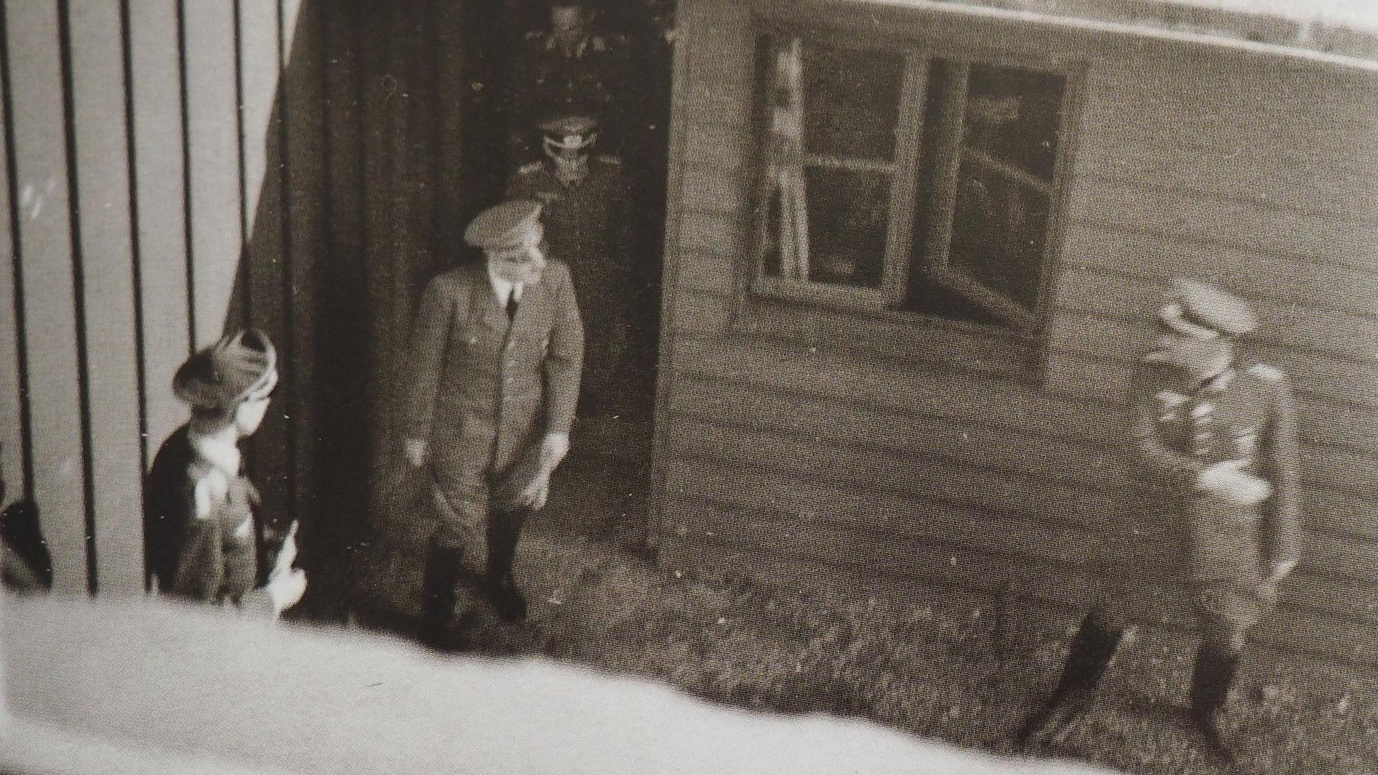 Ein heimlich aufgenommenes Schwarz-Weiß-Foto zeigt Adolf Hitler, wie er bei Bad Münstereifel-Rodert aus einer Tür ins Freie geht. Um ihn herum sind weitere Männer in Uniformen.