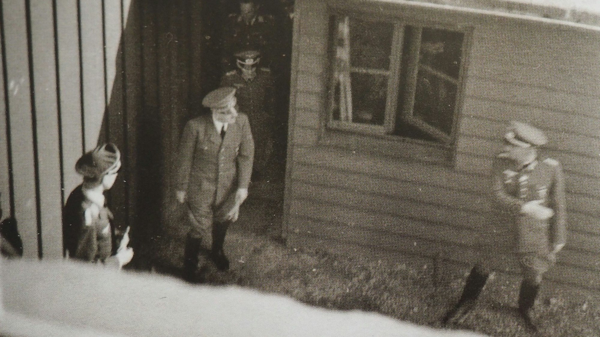 Ein heimlich aufgenommenes Schwarz-Weiß-Foto zeigt Adolf Hitler, wie er bei Bad Münstereifel-Rodert aus einer Tür ins Freie geht. Um ihn herum sind weitere Männer in Uniformen.