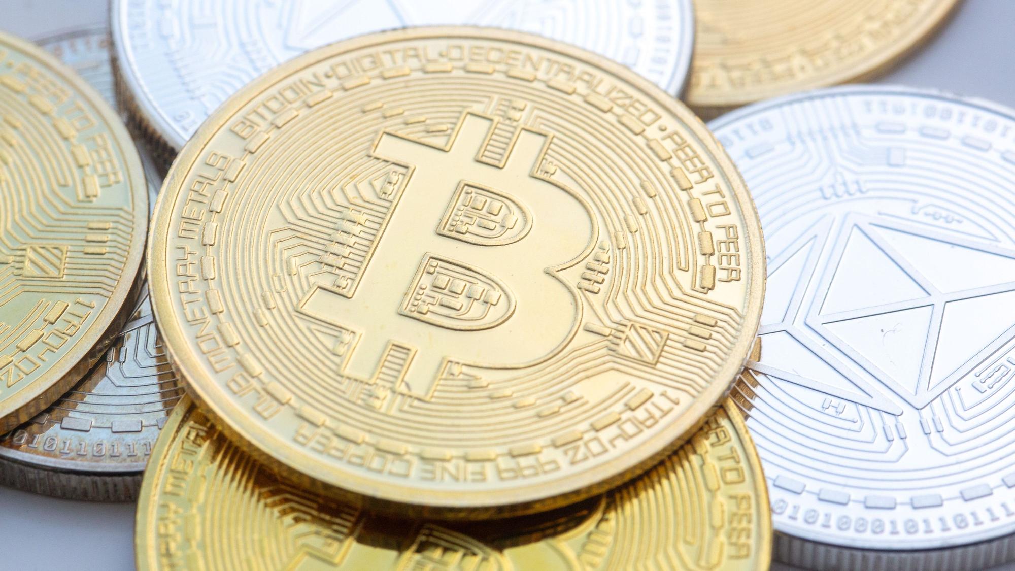 ILLUSTRATION - 10.11.2023, Berlin: Münzen mit den Symbolen von Bitcoin (M) und Ethereum sind auf einem Tisch angeordnet. (zu dpa: «Trump ordnet Reserve von Digitalwährungen an») Foto: Fernando Gutierrez-Juarez/dpa +++ dpa-Bildfunk +++