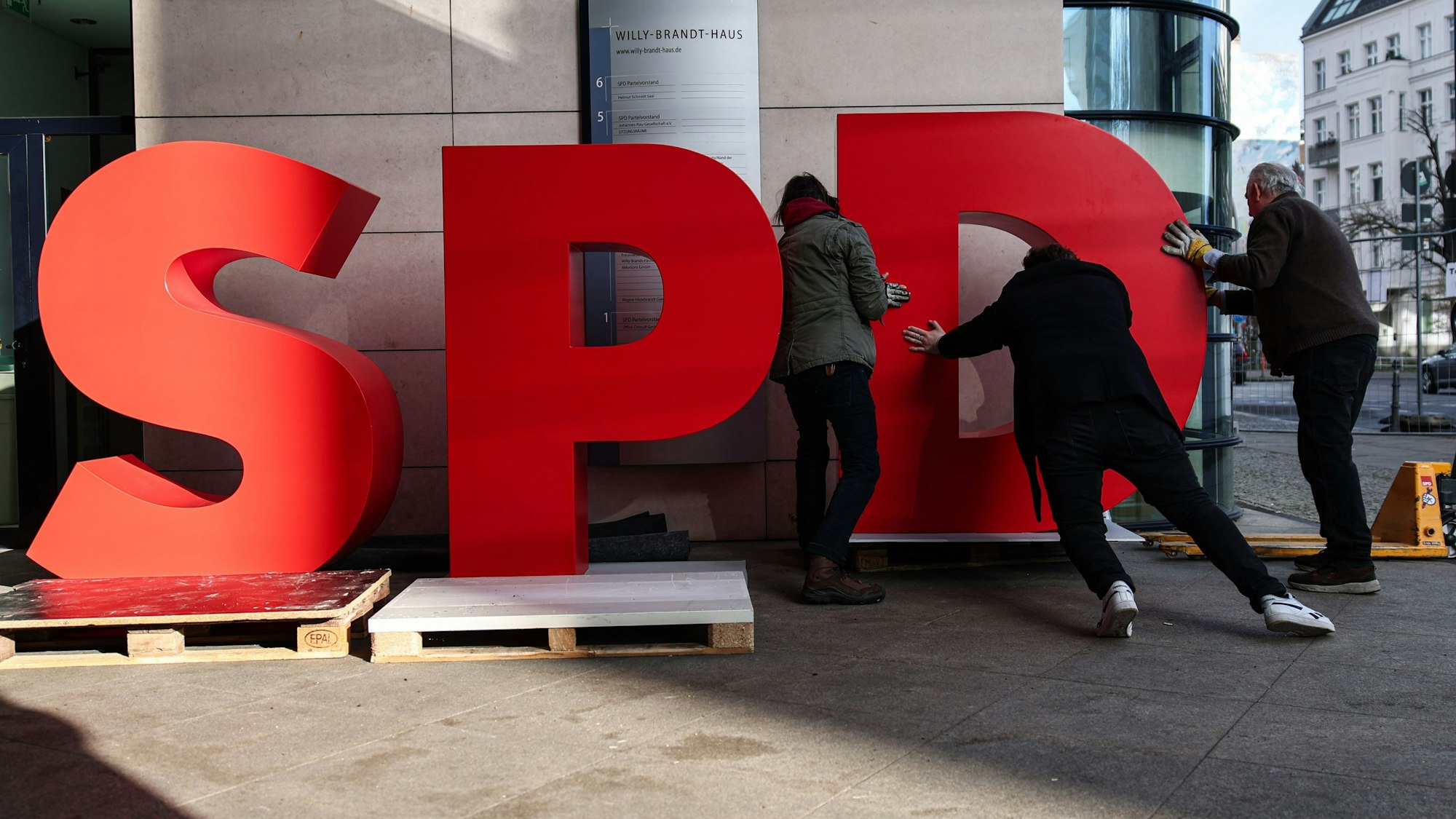 Arbeiter demontieren einen SPD-Schriftzug vor dem Willy-Brandt-Haus.