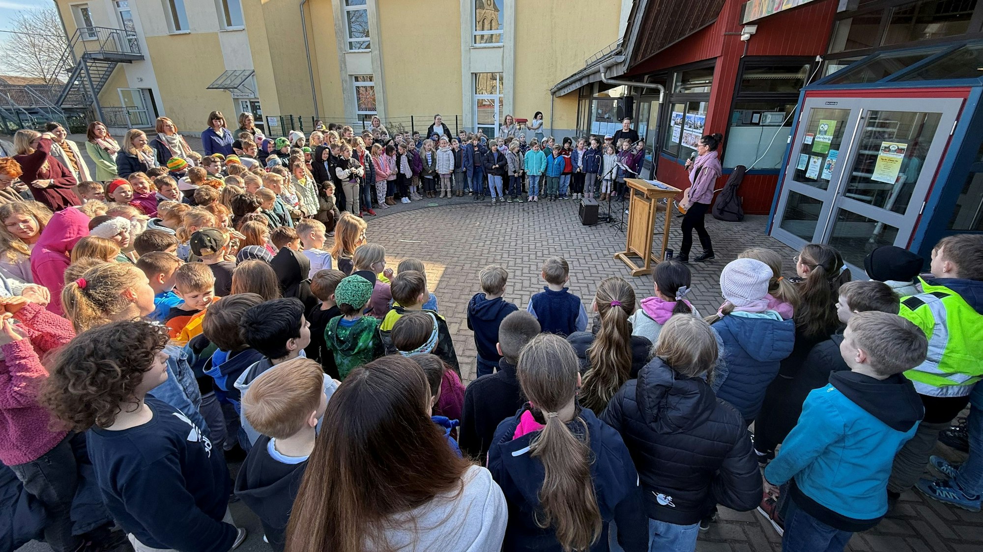 Die Kinder versammelten sich auf dem Schulhof und begrüßten die Gäste mit einem Lied.