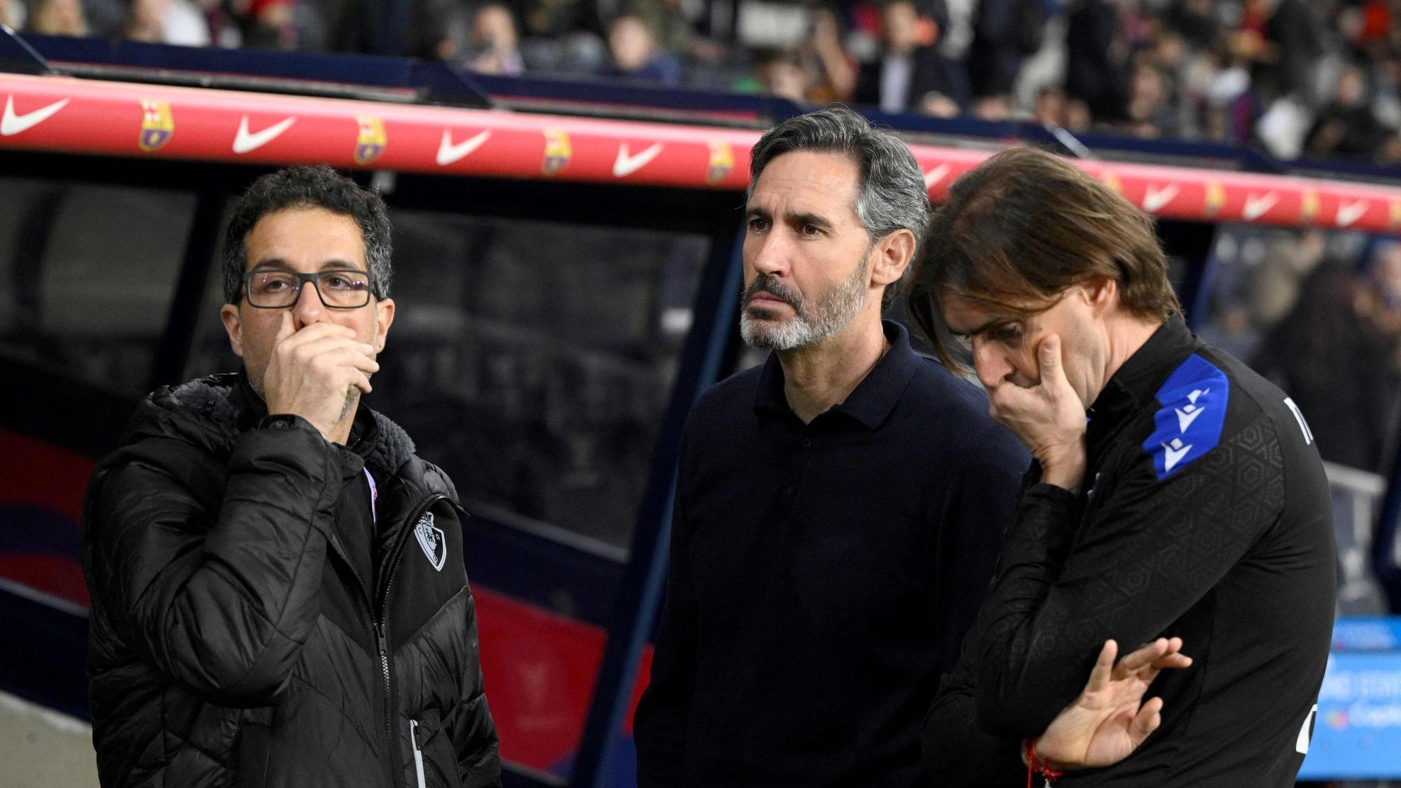 Vicente Osasuna's Spanish coach Vicente Moreno (C) and staff members react upon the decision to cancel the Spanish league football match between FC Barcelona and CA Osasuna at Estadi Olimpic Lluis Companys in Barcelona on March 8, 2025. The match was cancelled due to the decease of the FC Barcelona's team doctor Carlos Minarro Garcia. (Photo by Josep LAGO / AFP)