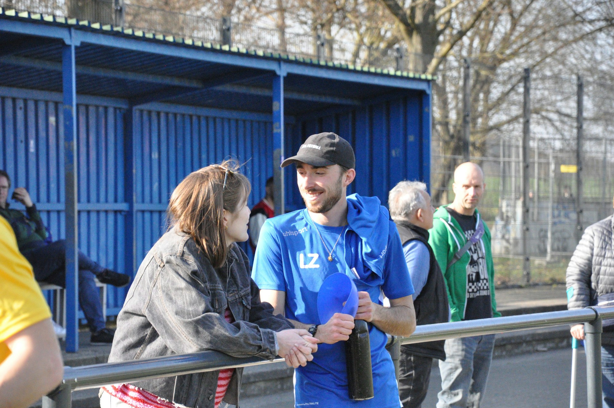 Das Foto zeigt einen entspannten Trainer im Gespräch mit einer Zuschauerin.