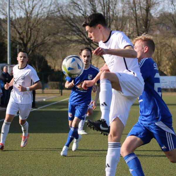 Nierfeld Yannick Lenhard nimmt einen Ball akrobatisch an, während ein Gegenspieler ihn bedrängt.