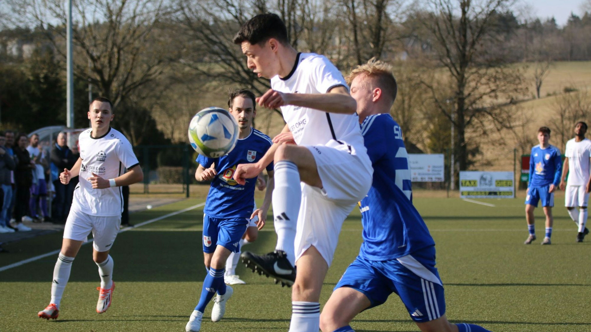 Nierfeld Yannick Lenhard nimmt einen Ball akrobatisch an, während ein Gegenspieler ihn bedrängt.