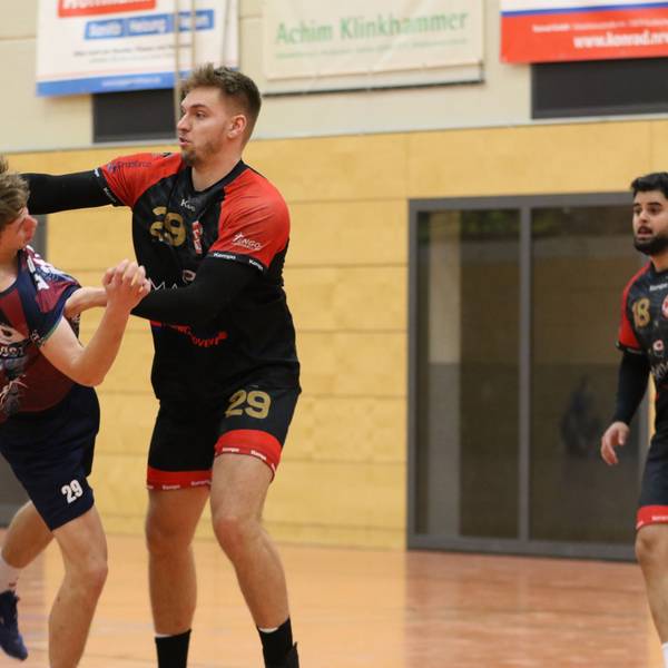 Palmersheims Robin Voiß greift mit beiden Armen den ballführenden Gegner an. Eine Hand geht an den Oberarm, die andere an die Brust. Ein Mitspieler und ein Gegenspieler schauen zu.