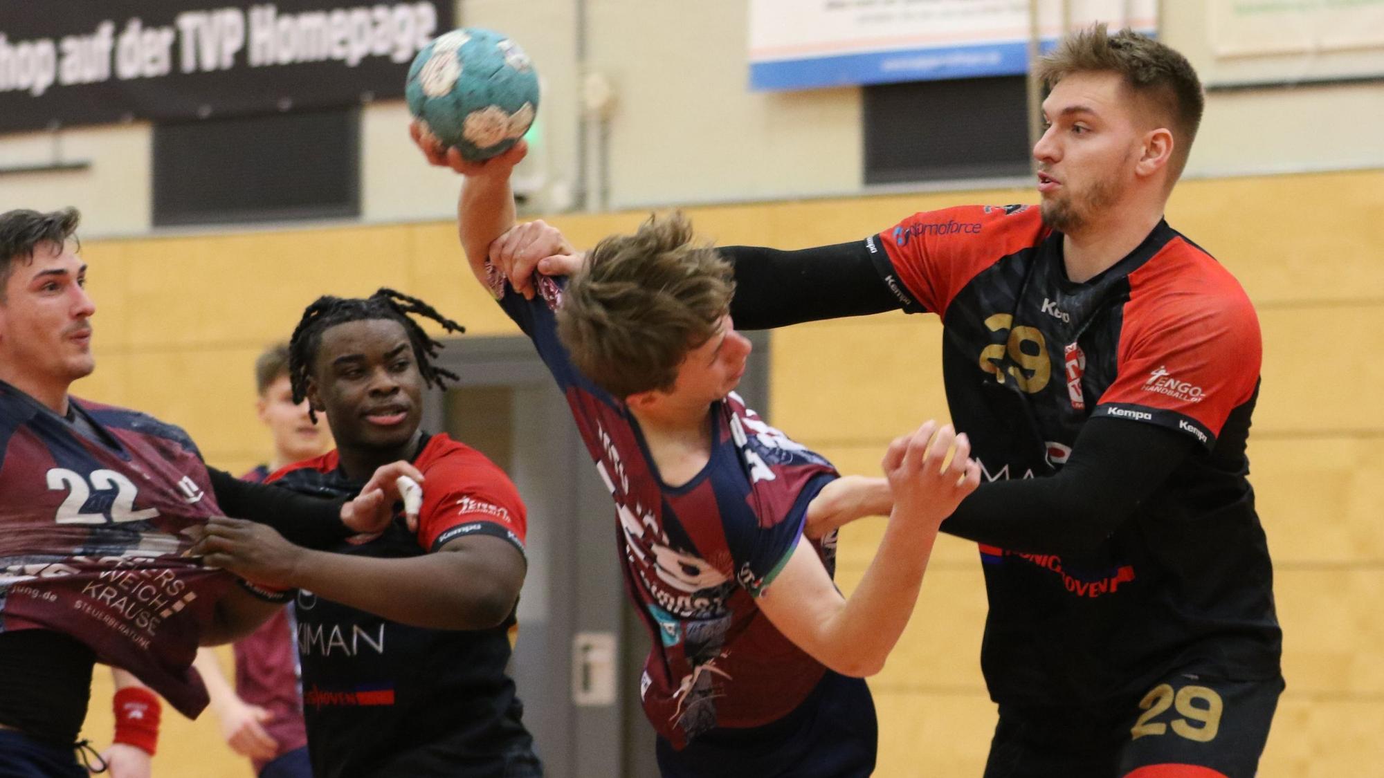 Palmersheims Robin Voiß greift mit beiden Armen den ballführenden Gegner an. Eine Hand geht an den Oberarm, die andere an die Brust. Ein Mitspieler und ein Gegenspieler schauen zu.
