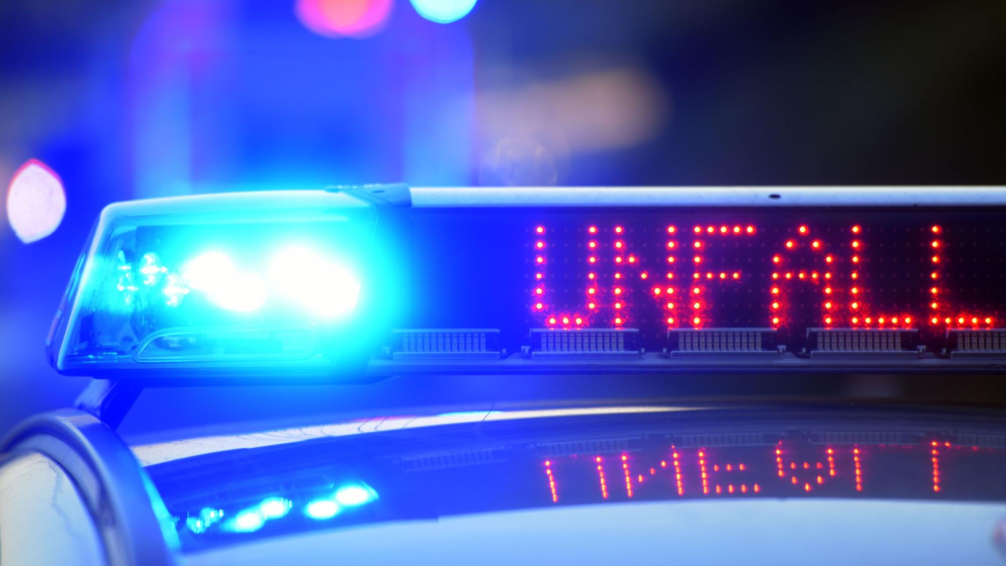 Auf einem Polizeifahrzeug warnt auf der Autobahn A8 eine Leuchtschrift vor einer Unfallstelle.