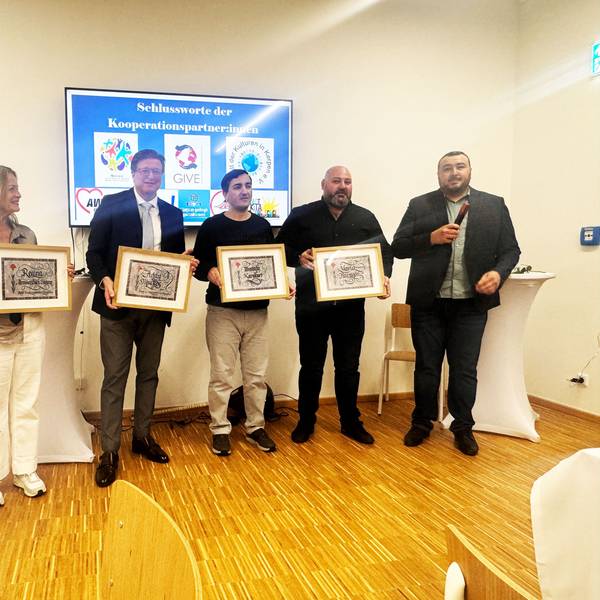 Auf dem Bild stehen Karina Dierks, Regina Hemmersbach-Fontein, Addy Muckes, Mustafa Karakurt, Yavuz Karagöz in einer Reihe und halten Kalligrafien ihres Namens hoch. Daneben steht der Laudator Murat Gök.