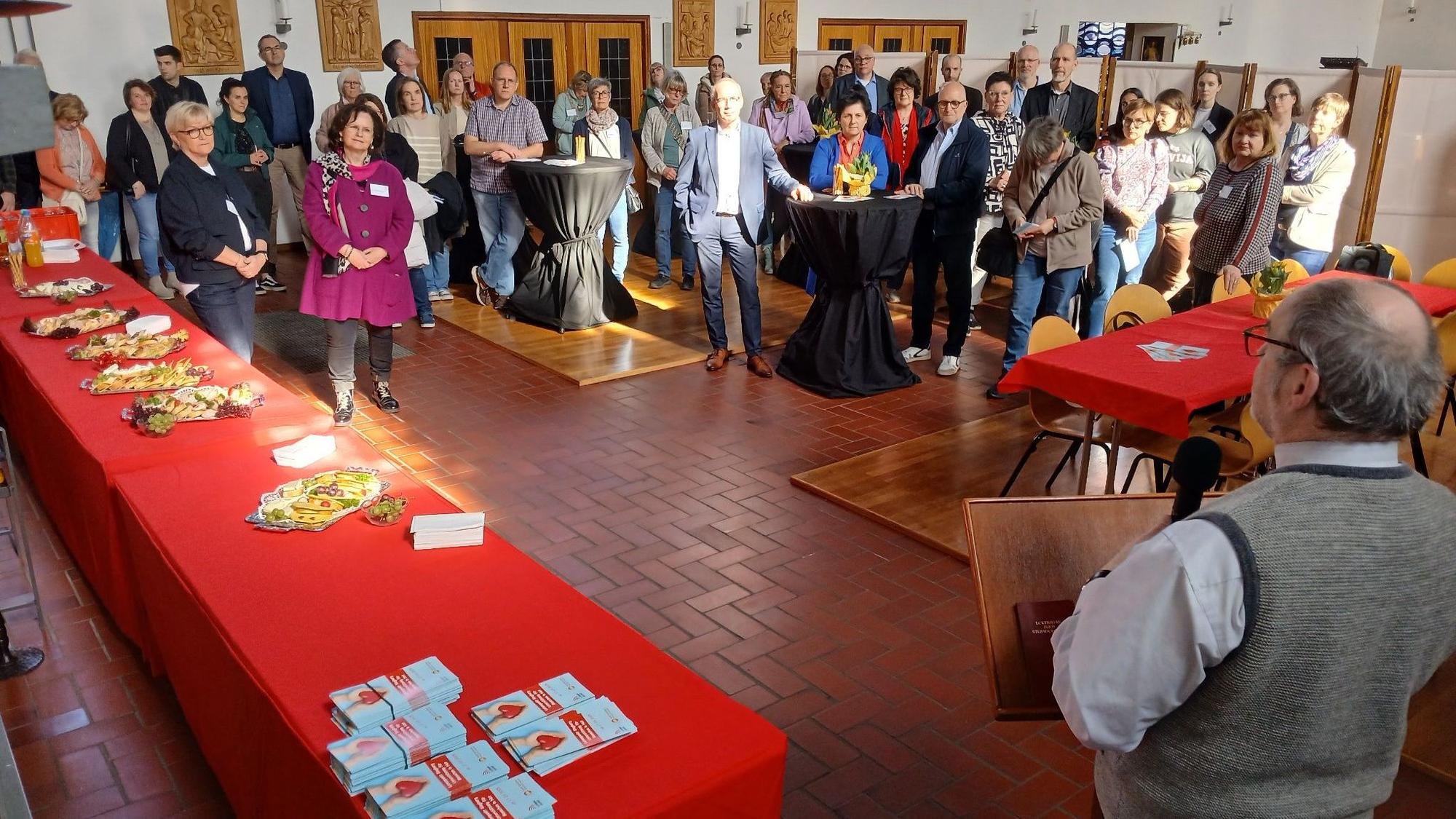 Menschen in einer Kirche, rechts im Vordergrund ein Redner.