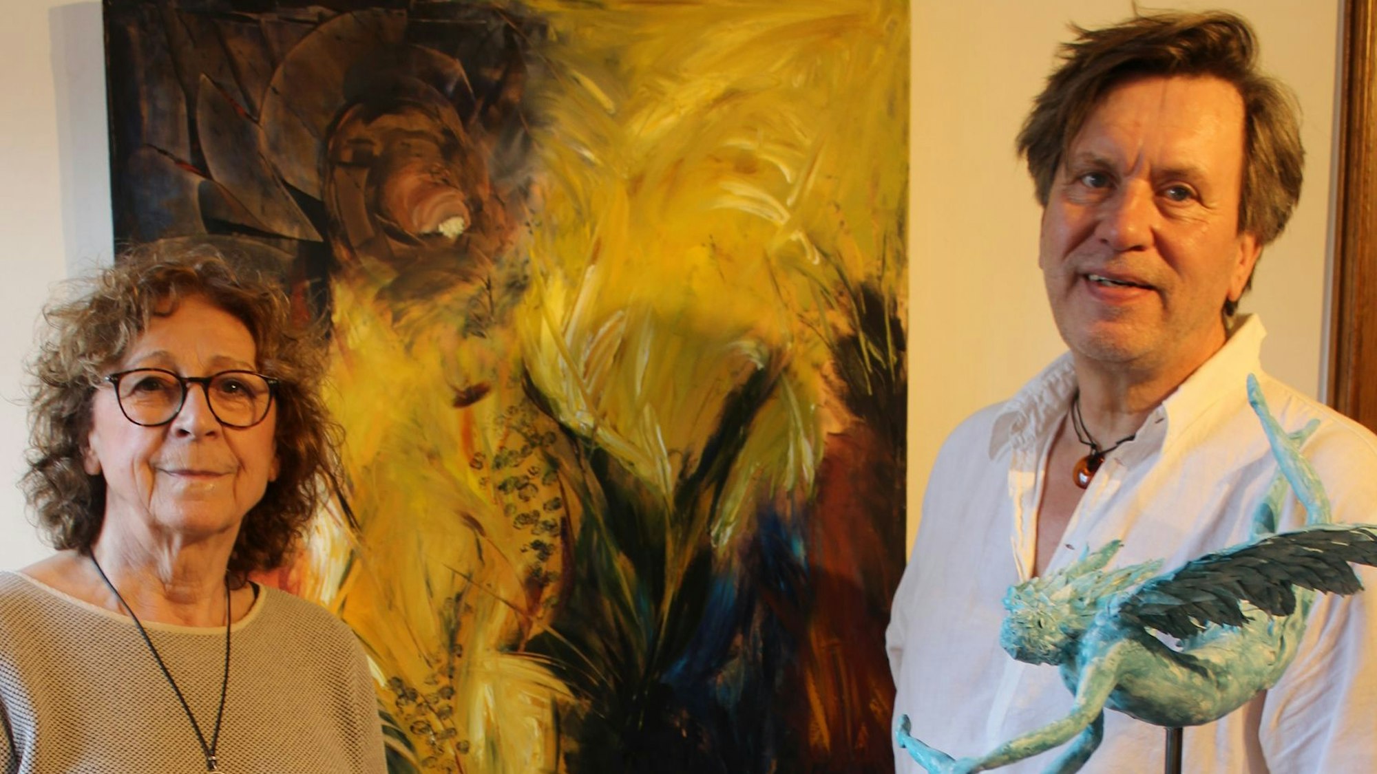 Zwei Menschen stehen neben einem Bild.