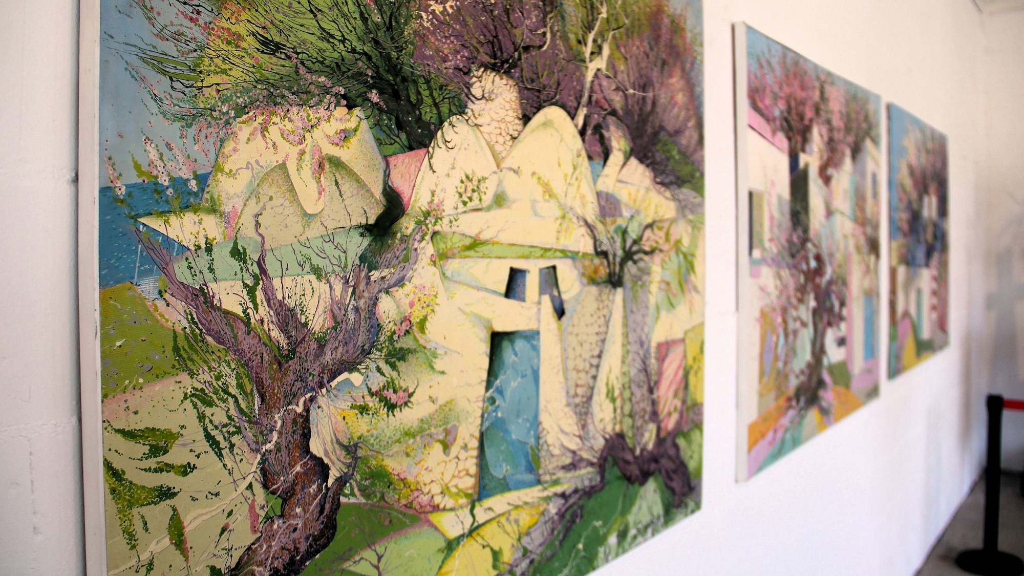 Drei großformatige Bilder hängen nebeneinander.