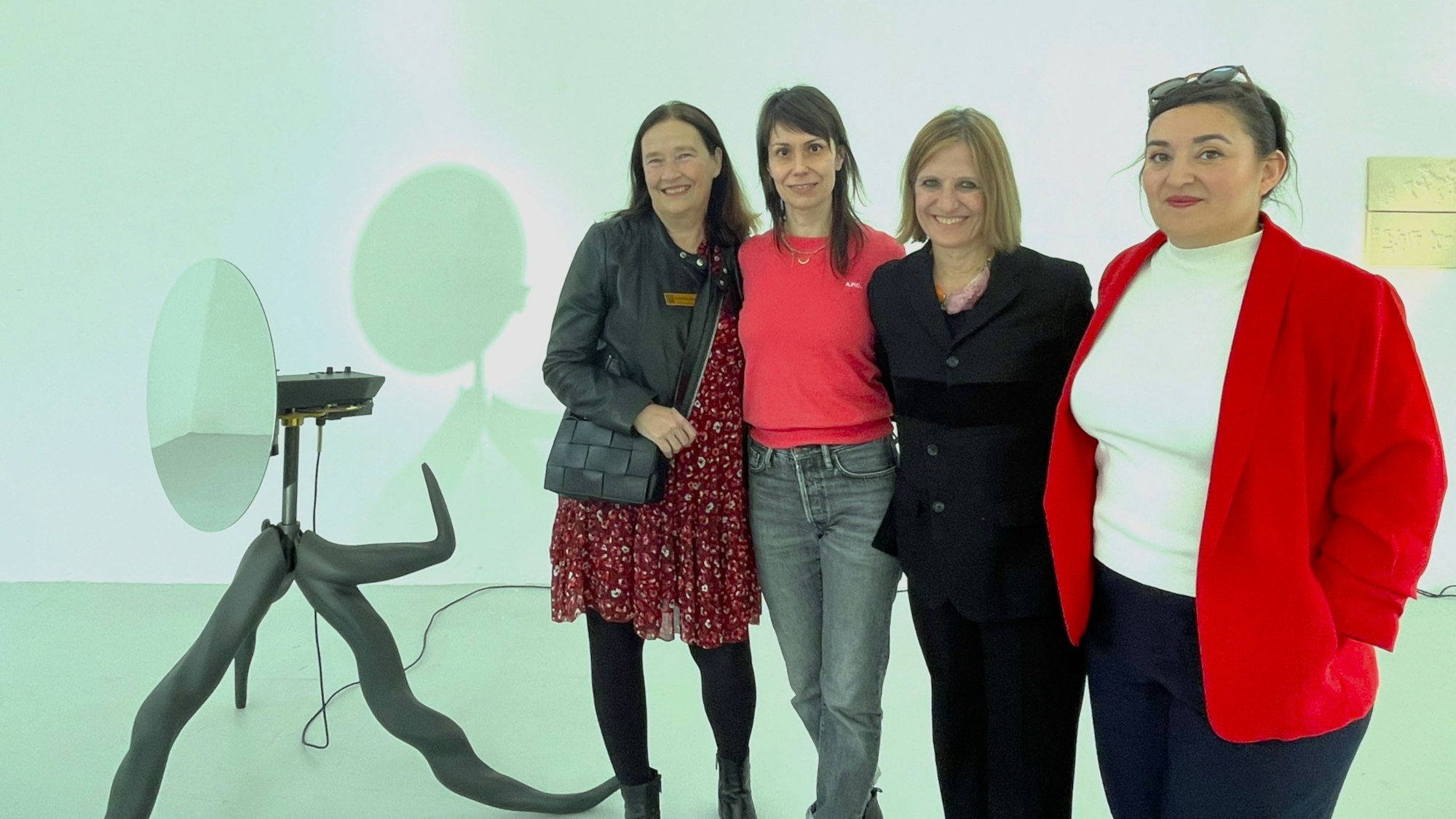 Vier Frauen stehen in der Fuhrwerkswaage / Ausstellungshalle. Links unten ein Kunstwerk: „Der Baum des Sehens“.