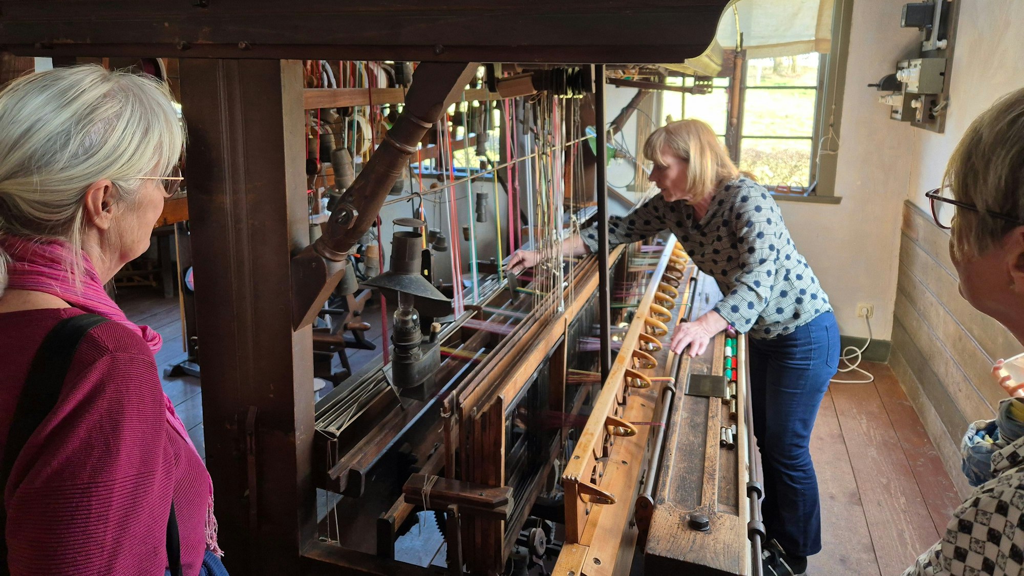 Eine Frau bedient einen Webstuhl.