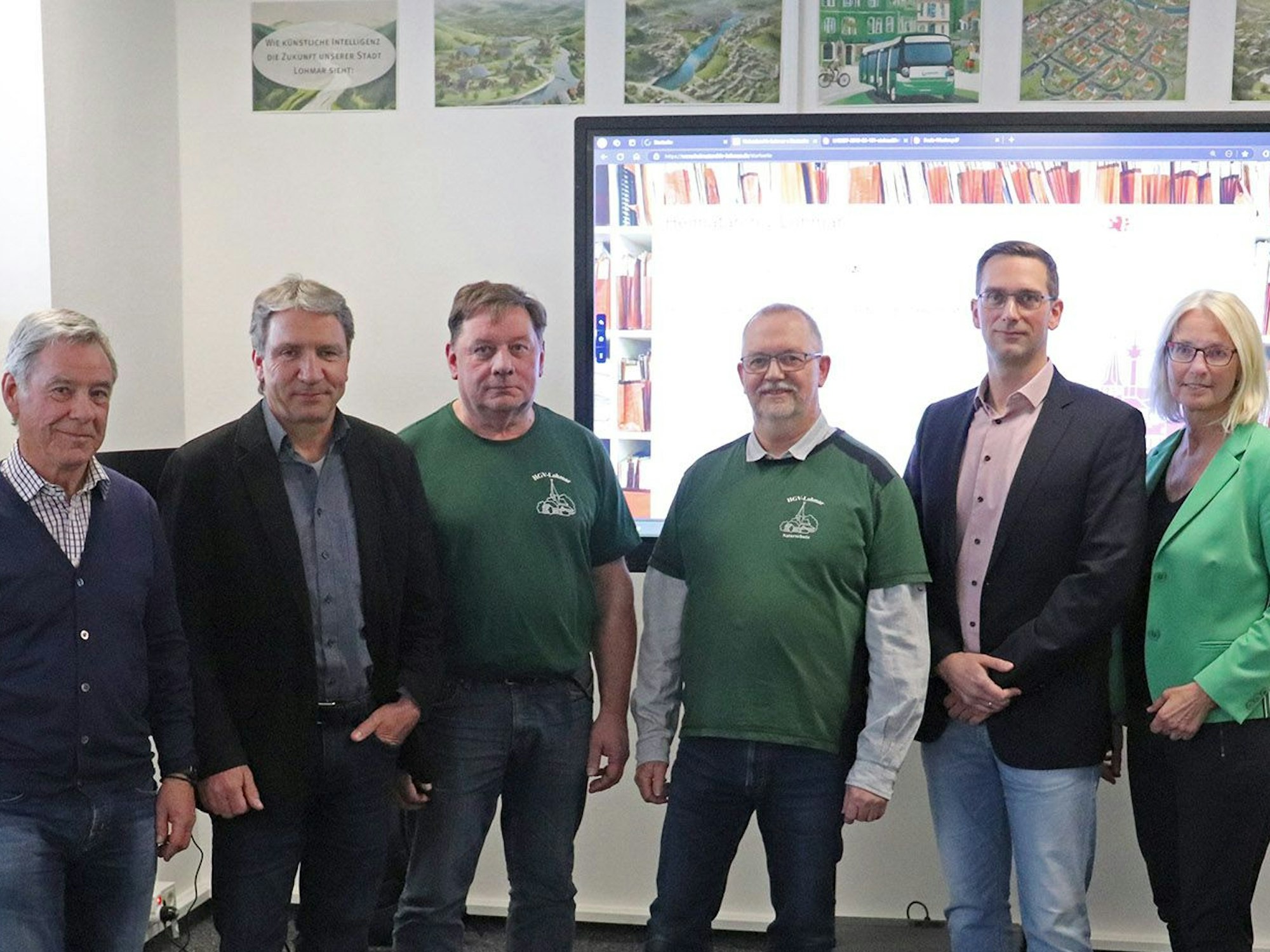 Fünf Männer und eine Frau vor einer Leinwand