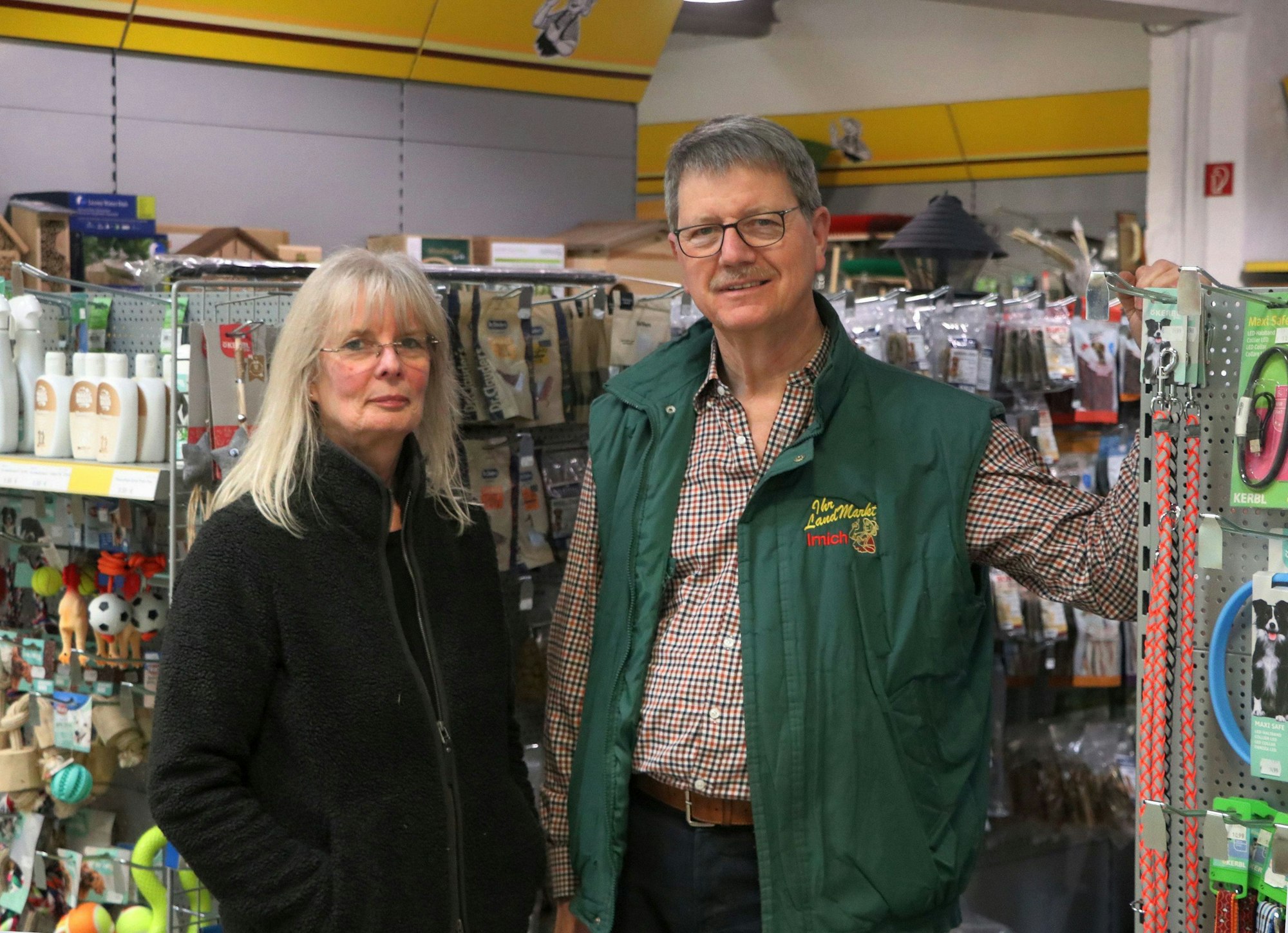 Auf dem Bild ist der Enkel des Firmengründers mit seiner Frau zu sehen, sie stehen vor Regalen mit Waren. Sie führen das Geschäft heute weiter.