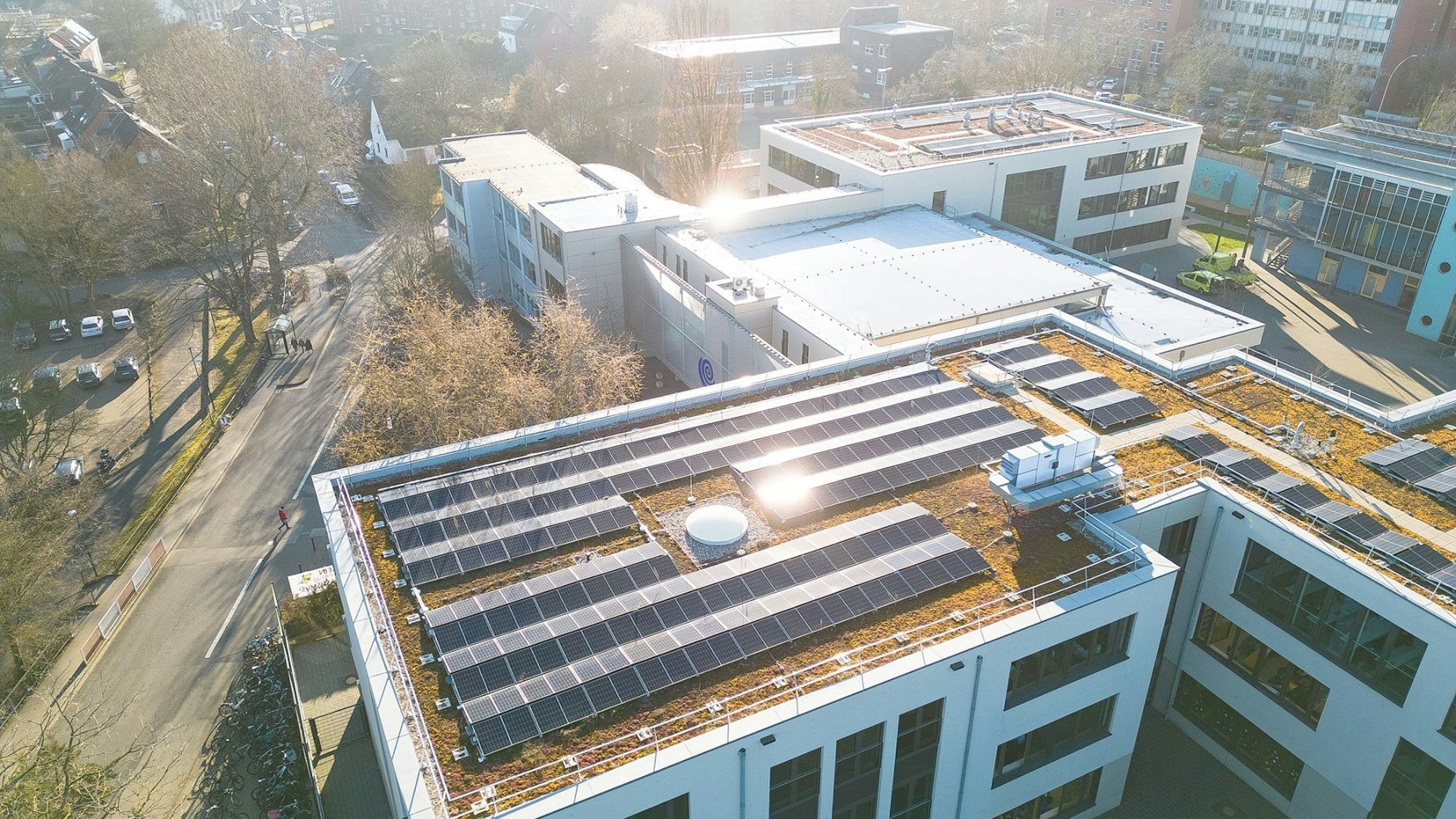 Die Luftaufnahme zeigt die Solarmodule auf den Dächern der Neubauten am Ernst-Mach-Gymnasium.